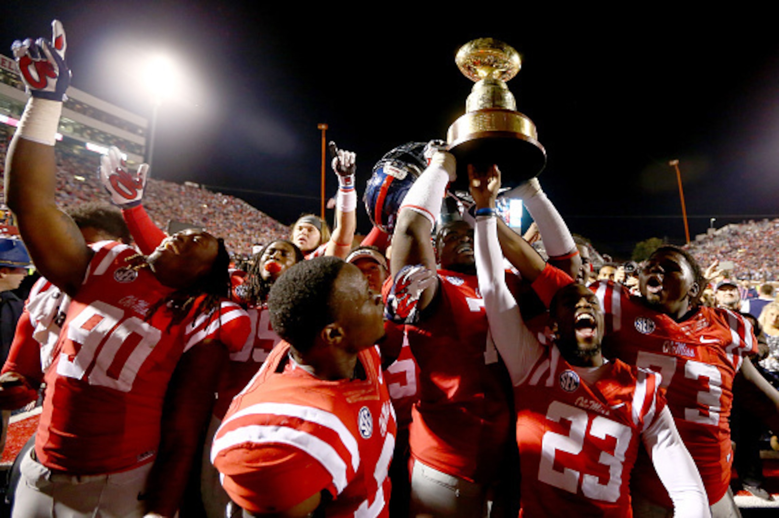 OXFORD, MS - NOVEMBER 29:  The Mississippi Rebels celebrate with the trophy after defeating the Mississippi State Bulldogs 31-17 at Vaught-Hemingway Stadium on November 29, 2014 in Oxford, Mississippi.  (Photo by Streeter Lecka/Getty Images)