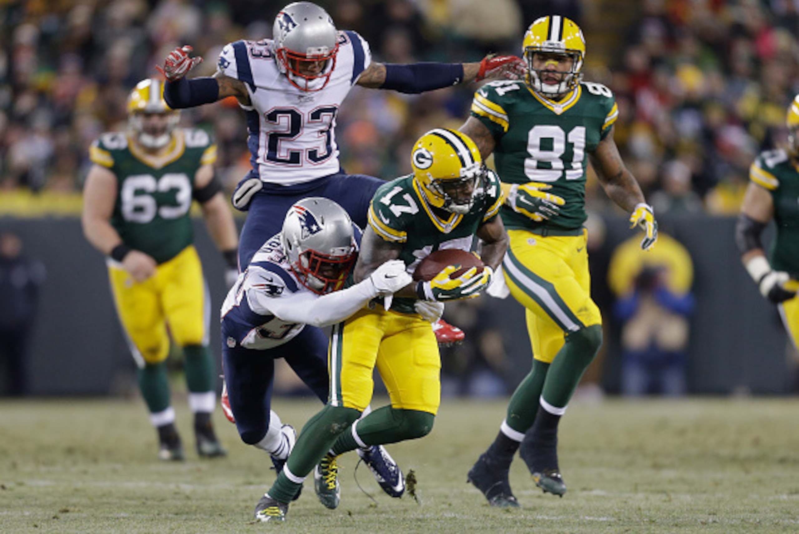 GREEN BAY, WI - NOVEMBER 30:  Strong safety Tavon Wilson #27 of the New England Patriots grabs wide receiver Davante Adams #17 of the Green Bay Packers as strong safety Patrick Chung #23 jumps behind, in the first half of the NFL game at Lambeau Field on 