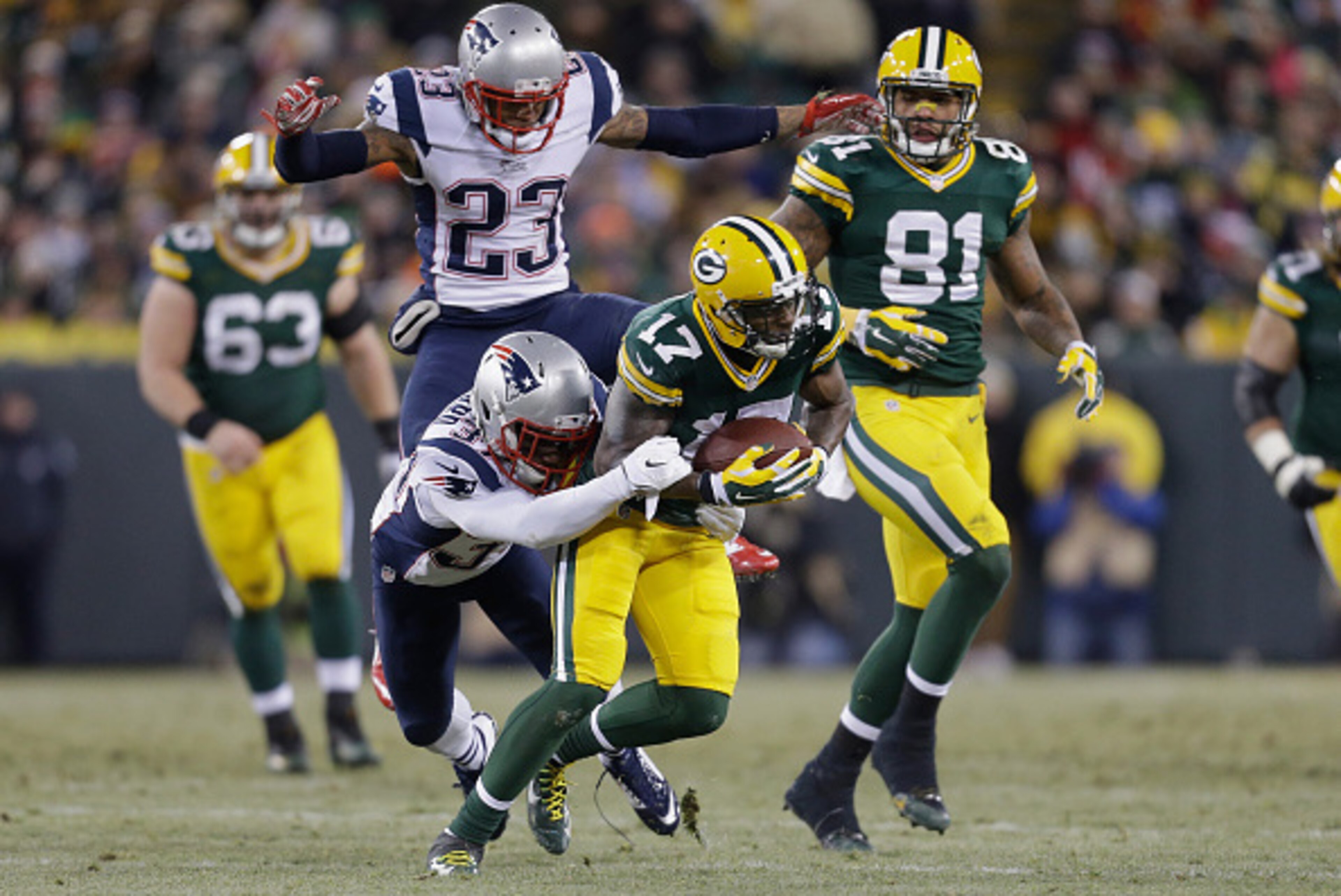 GREEN BAY, WI - NOVEMBER 30:  Strong safety Tavon Wilson #27 of the New England Patriots grabs wide receiver Davante Adams #17 of the Green Bay Packers as strong safety Patrick Chung #23 jumps behind, in the first half of the NFL game at Lambeau Field on 