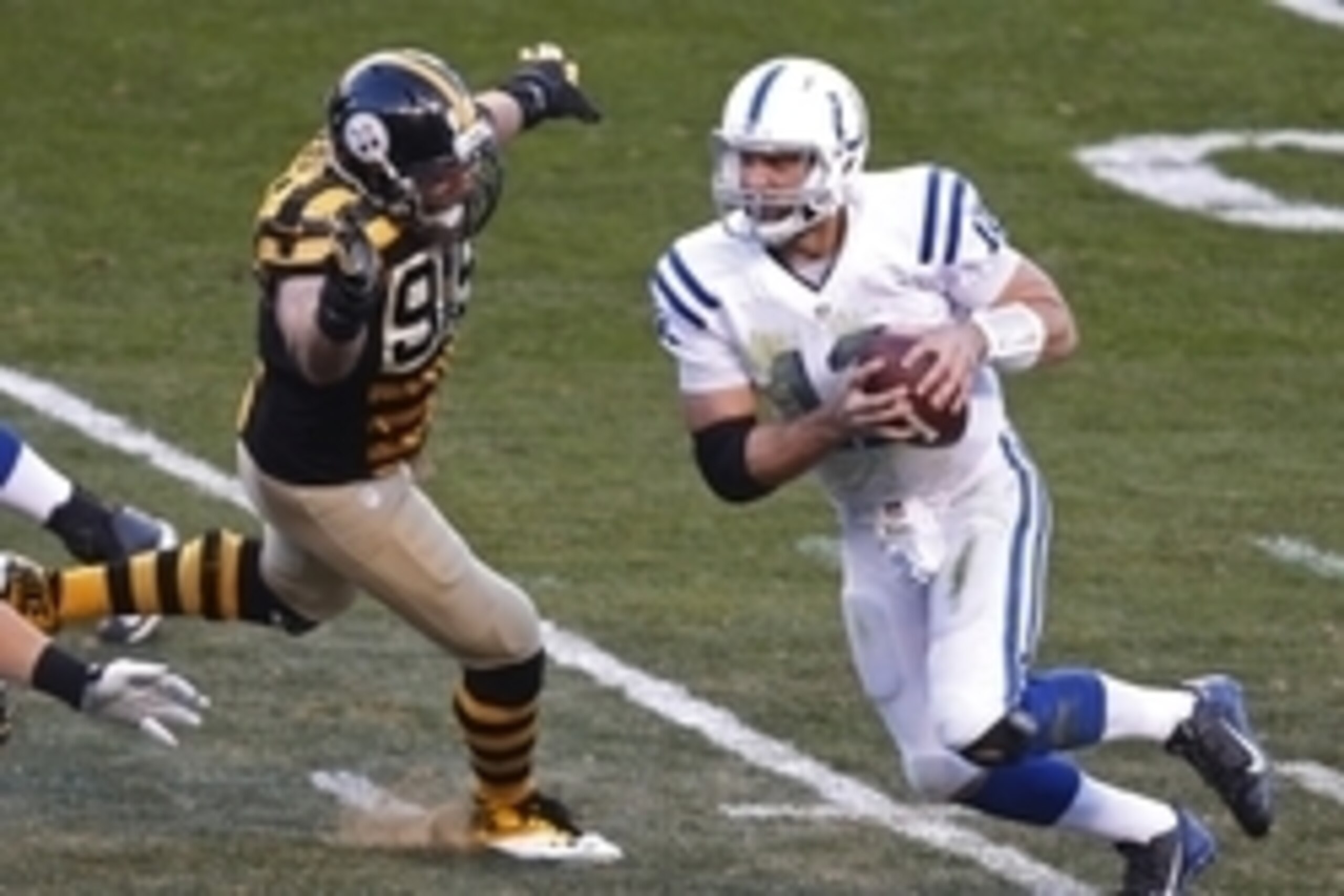 Oct 26, 2014; Pittsburgh, PA, USA; Indianapolis Colts quarterback Andrew Luck (12) scrambles with the ball as Pittsburgh Steelers defensive end Brett Keisel (99) pursues during the second quarter at Heinz Field. Mandatory Credit: Charles LeClaire-USA TODA