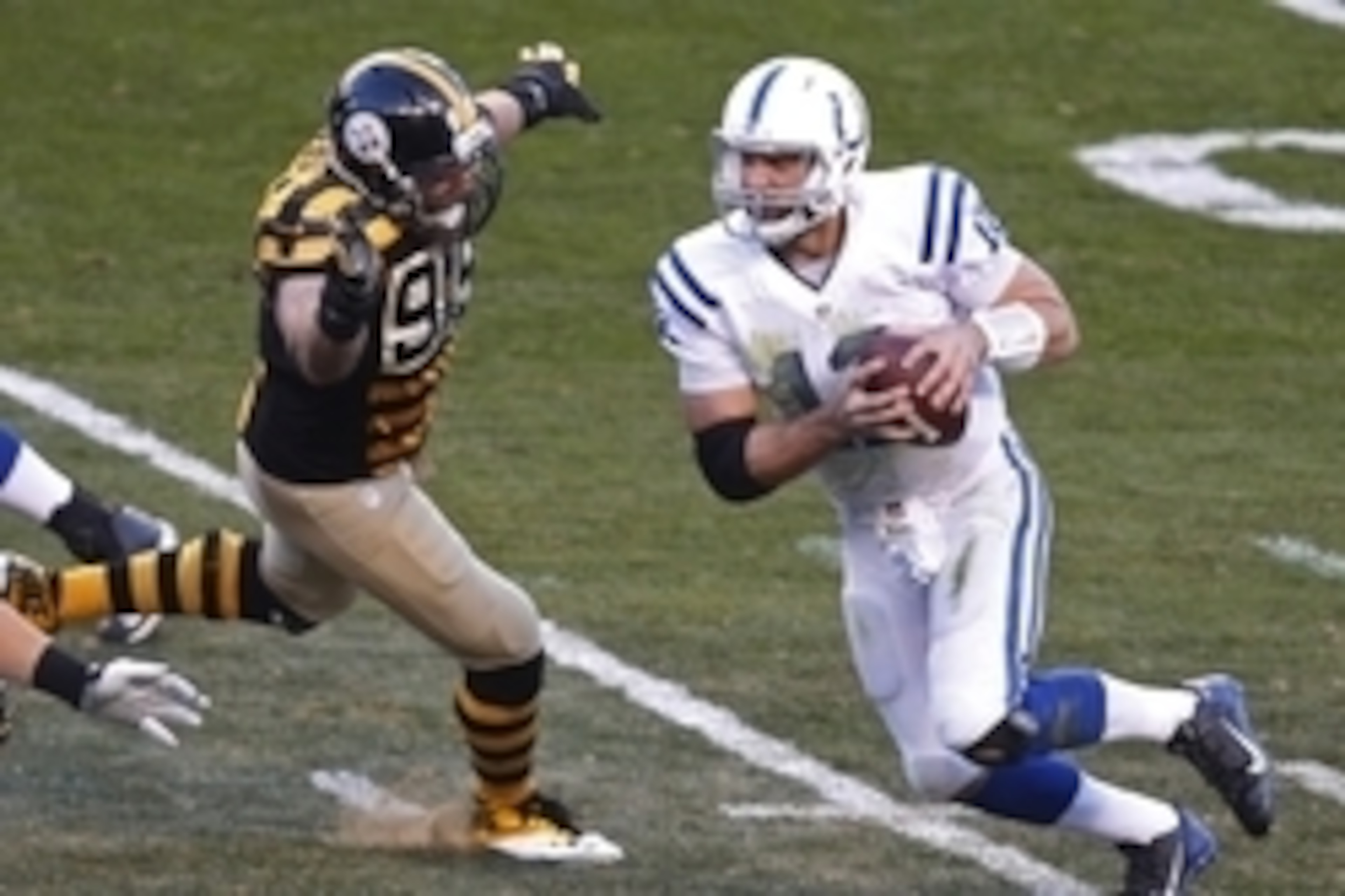 Oct 26, 2014; Pittsburgh, PA, USA; Indianapolis Colts quarterback Andrew Luck (12) scrambles with the ball as Pittsburgh Steelers defensive end Brett Keisel (99) pursues during the second quarter at Heinz Field. Mandatory Credit: Charles LeClaire-USA TODA