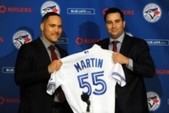 Nov 20, 2014; Toronto, Ontario, CAN;  Toronto Blue Jays catcher Russell Martin (left) receives his jersey from general manager Alex Anthopoulos after being introduced at a press conference at Rogers Centre. Mandatory Credit: Dan Hamilton-USA TODAY Sports