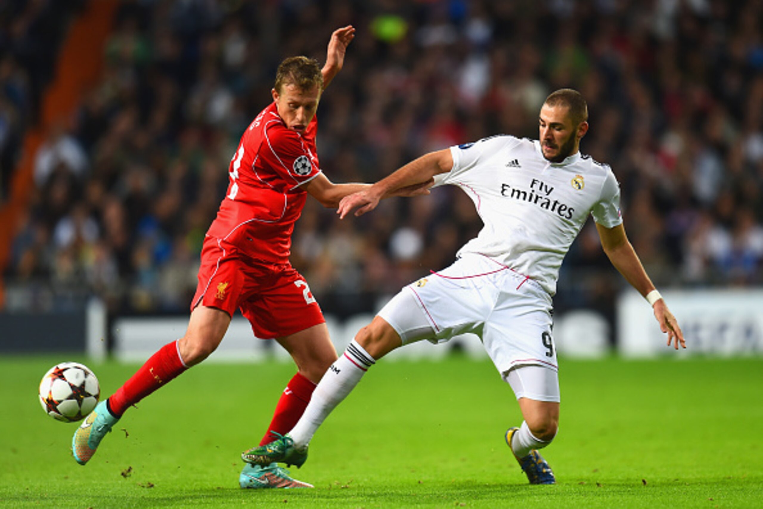 MADRID, SPAIN - NOVEMBER 04:  Lucas Leiva of Liverpool is challneged by Karim Benzema of Real Madrid CF during the UEFA Champions League Group B match between Real Madrid CF and Liverpool FC at Estadio Santiago Bernabeu on November 4, 2014 in Madrid, Spai