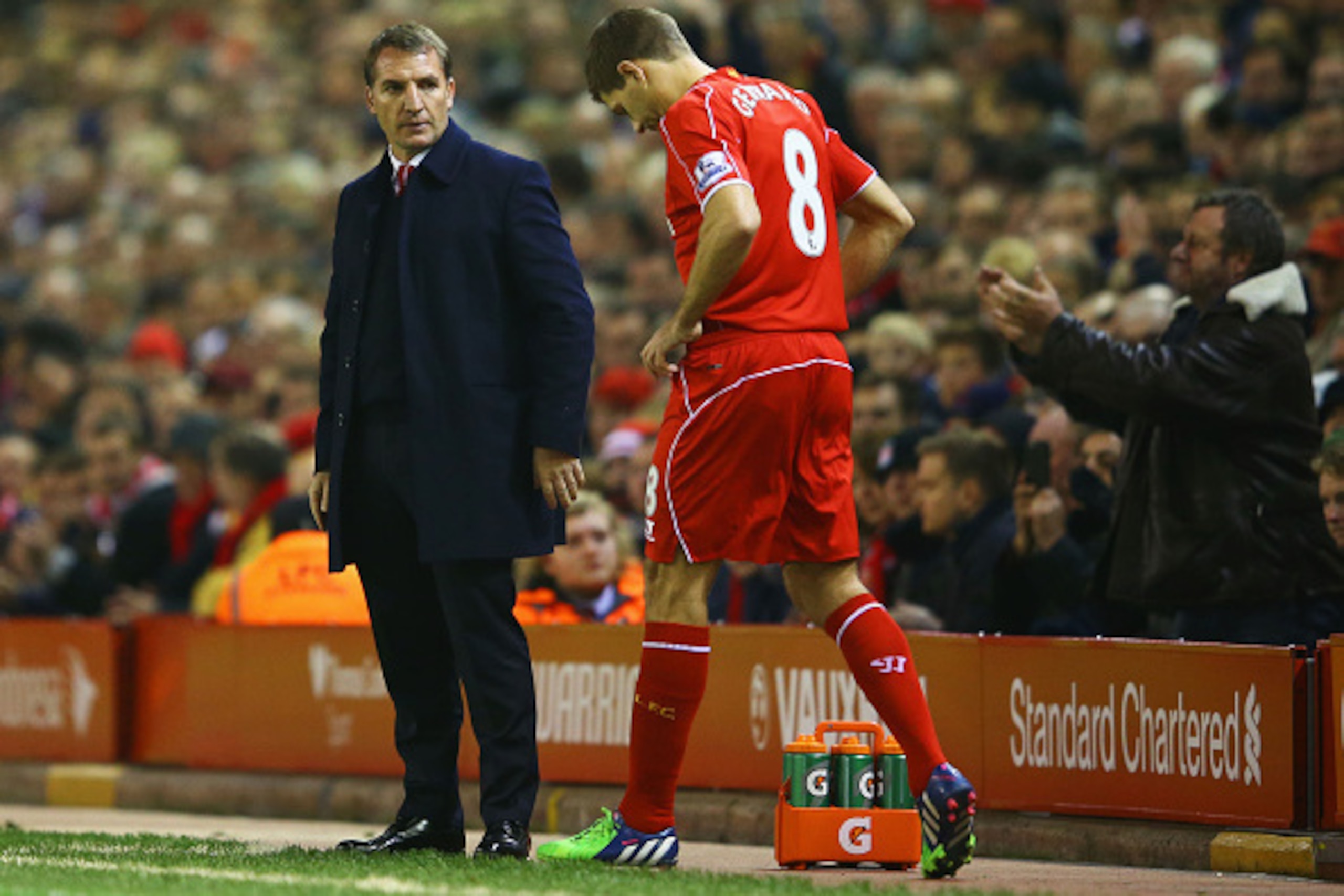 LIVERPOOL, ENGLAND - NOVEMBER 29:  A fan applauds as Steven Gerrard of Liverpool prepares to come onto the pitch as a substitute alongside Brendan Rodgers manager of Liverpool during the Barclays Premier League match between Liverpool and Stoke City at An