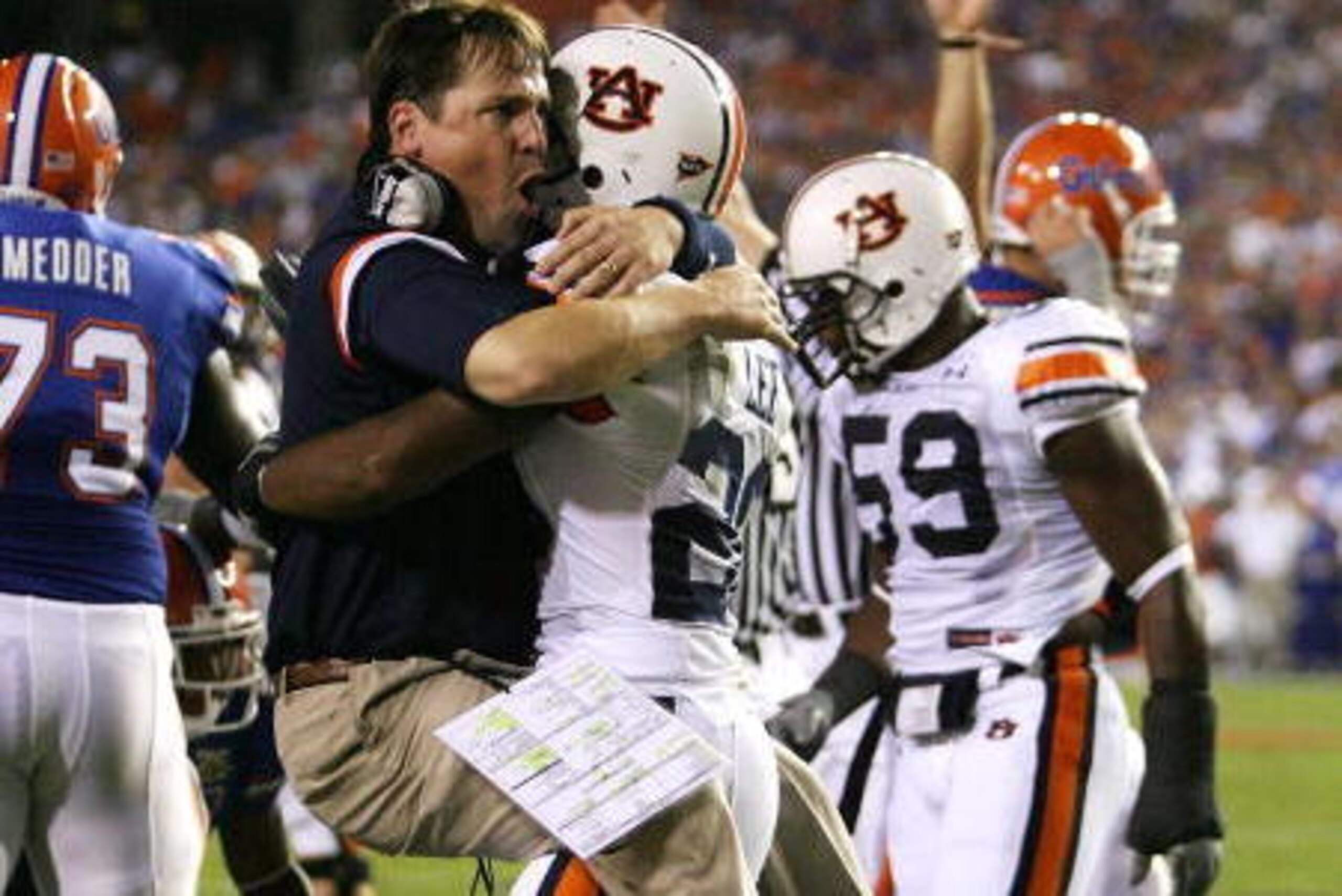 GAINESVILLE, FL - SEPTEMBER 29:  Defensive coordinator Will Muschamp of the Auburn Tigers jumps into the arms of defensive back Patrick Lee #20 after Lee helped cause a fumble late in the first half against the Florida Gators at Ben Hill Griffin Stadium S