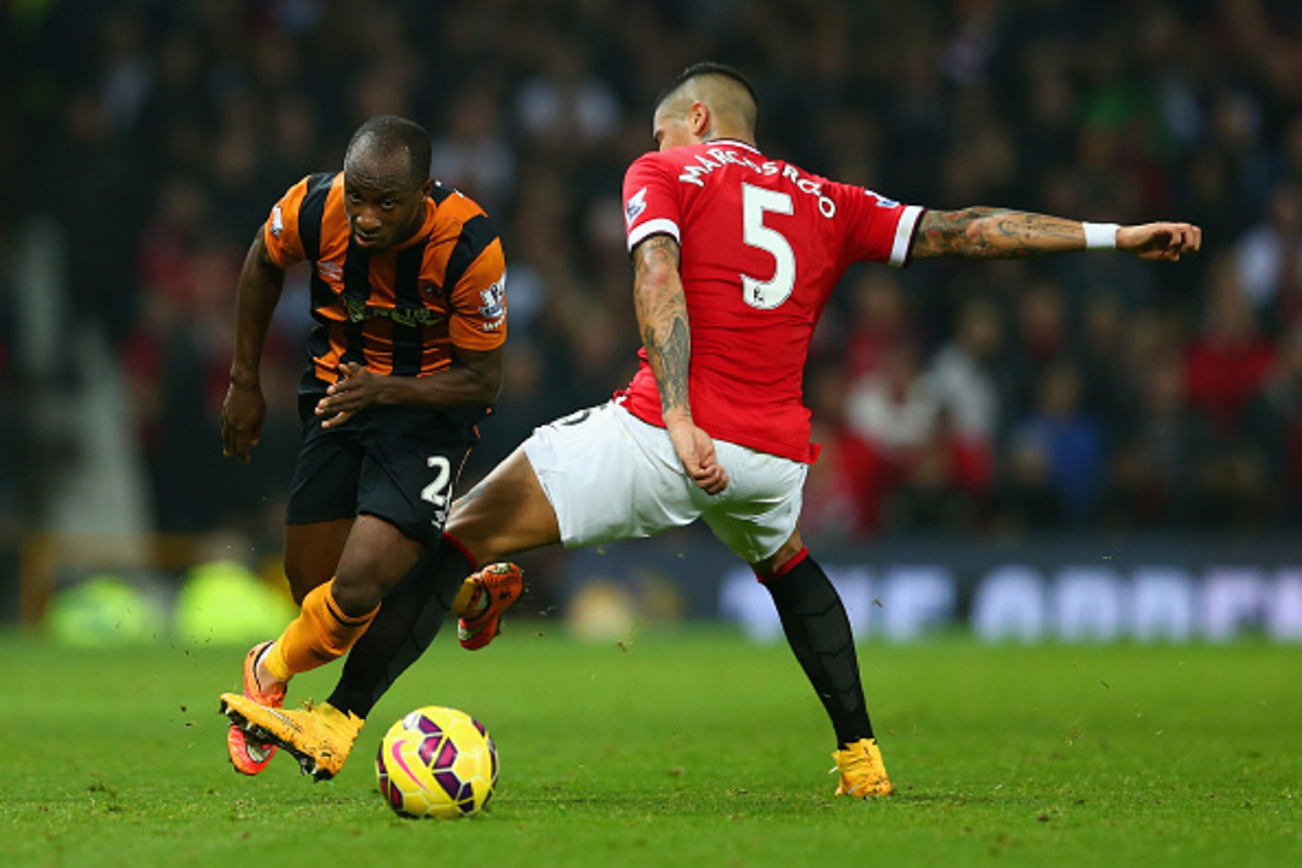 MANCHESTER, ENGLAND - NOVEMBER 29:  Marcos Rojo of Manchester United tackles Sone Aluko of Hull City during the Barclays Premier League match between Manchester United and Hull City at Old Trafford on November 29, 2014 in Manchester, England.  (Photo by M