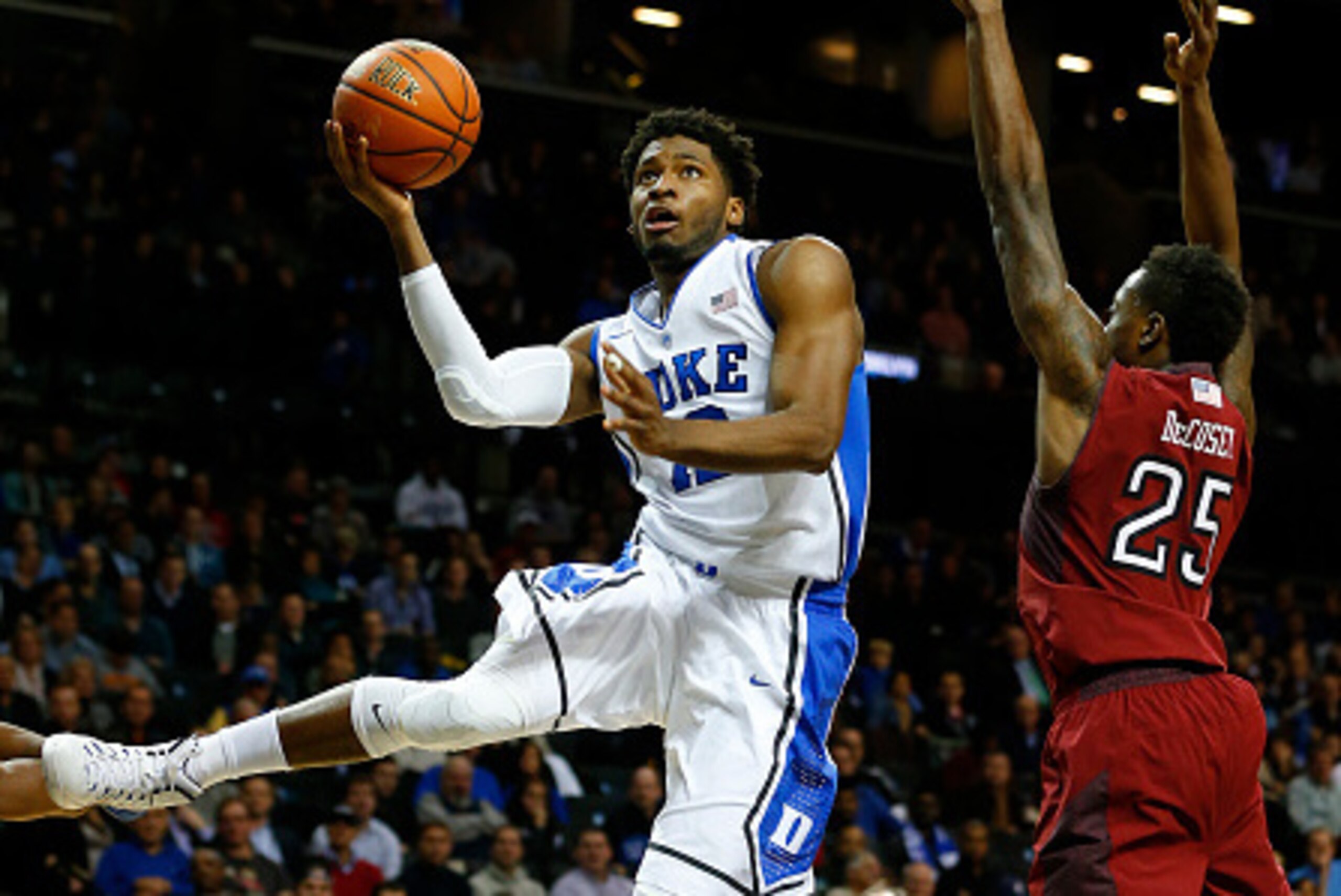 NEW YORK, NY - NOVEMBER 21: Justise Winslow #12 of the Duke Blue Devils goes to the basket as Quenton DeCosey #25 of the Temple Owls fdefends in the first half of a game in the Coaches vs Cancer Classic men's basketball tournament at Barclays Center on No