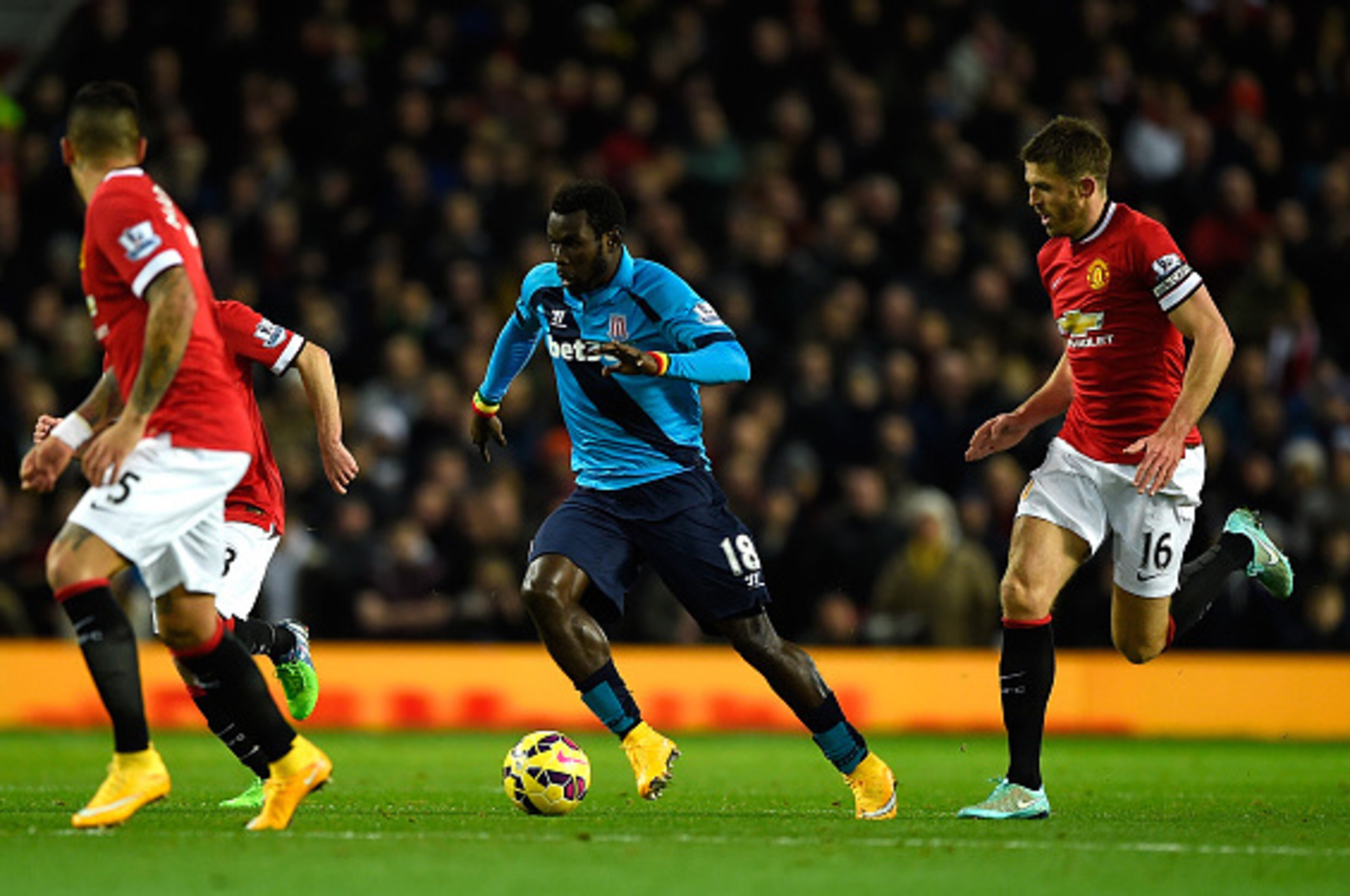 MANCHESTER, ENGLAND - DECEMBER 02:  Mame Diouf of Stoke City competes with Michael Carrick of Manchester United during the Barclays Premier League match between Manchester United and Stoke City at Old Trafford on December 2, 2014 in Manchester, England.  
