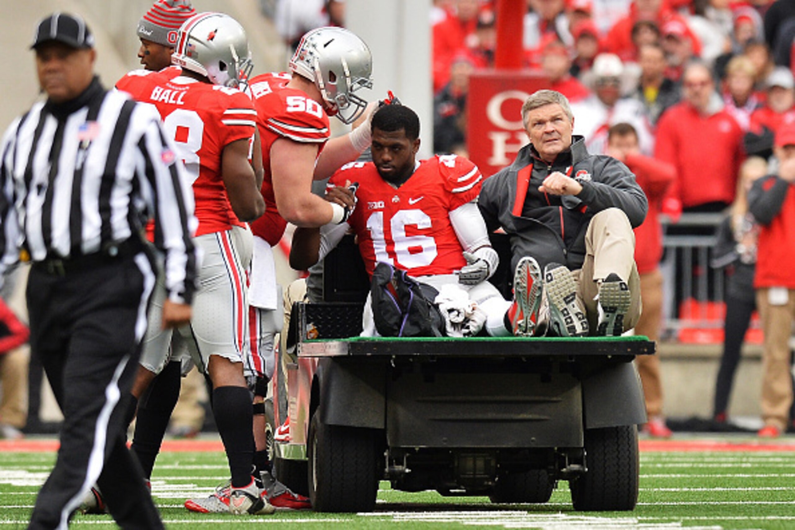 COLUMBUS, OH - NOVEMBER 29:  Quarterback J.T. Barrett #16 of the Ohio State Buckeyes is comforted by Jacoby Boren #50 of the Ohio State Buckeyes as Barrett is taken off the field after injuring his leg in the fourth quarter against the Michigan Wolverines