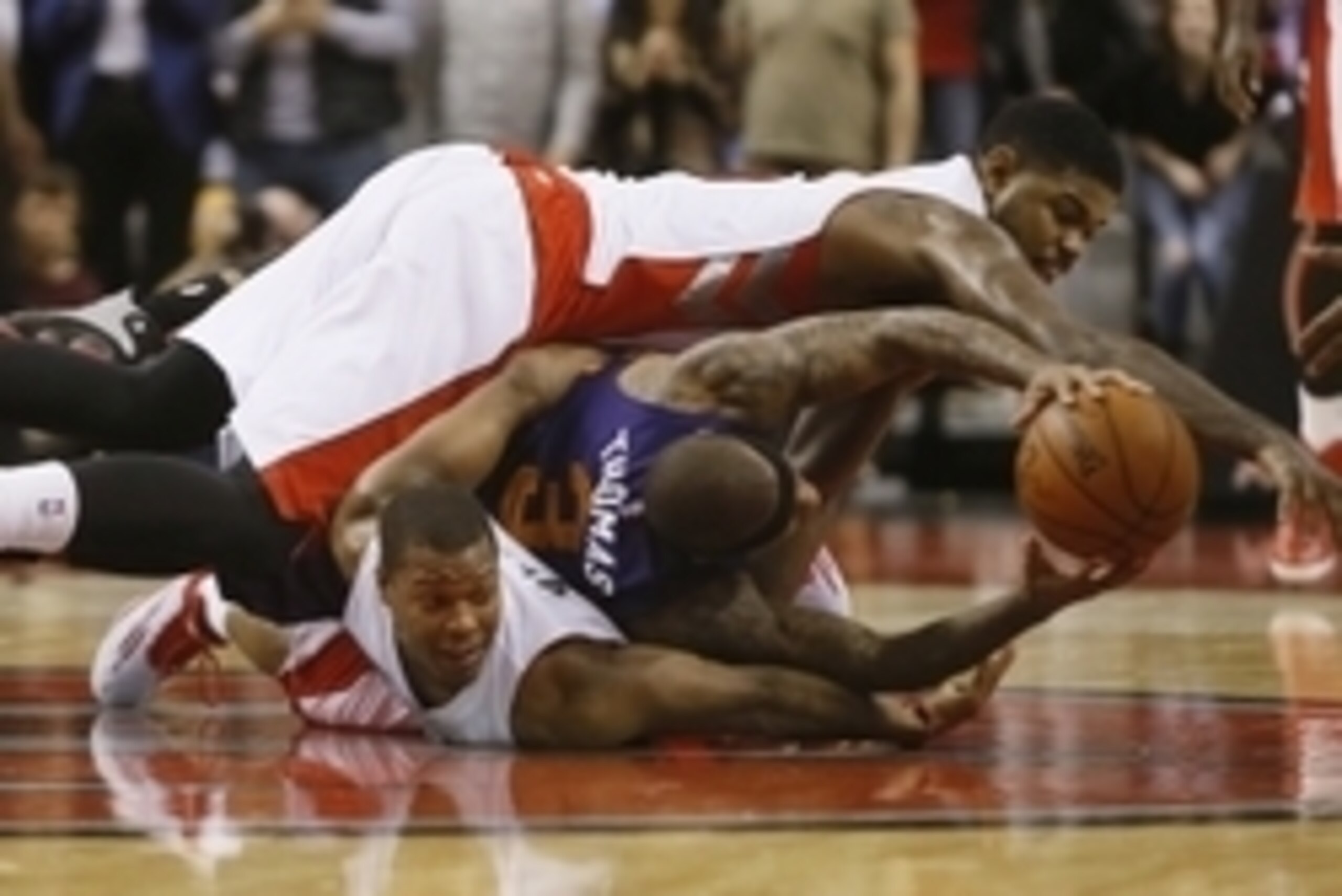 Nov 24, 2014; Toronto, Ontario, CAN; Toronto Raptors forward Amir Johnson (15) and guard Kyle Lowry (7) and Phoenix Suns guard Isaiah Thomas (3) battle for the ball at the Air Canada Centre. Toronto defeated Phoenix 104-100. Mandatory Credit: John E. Soko