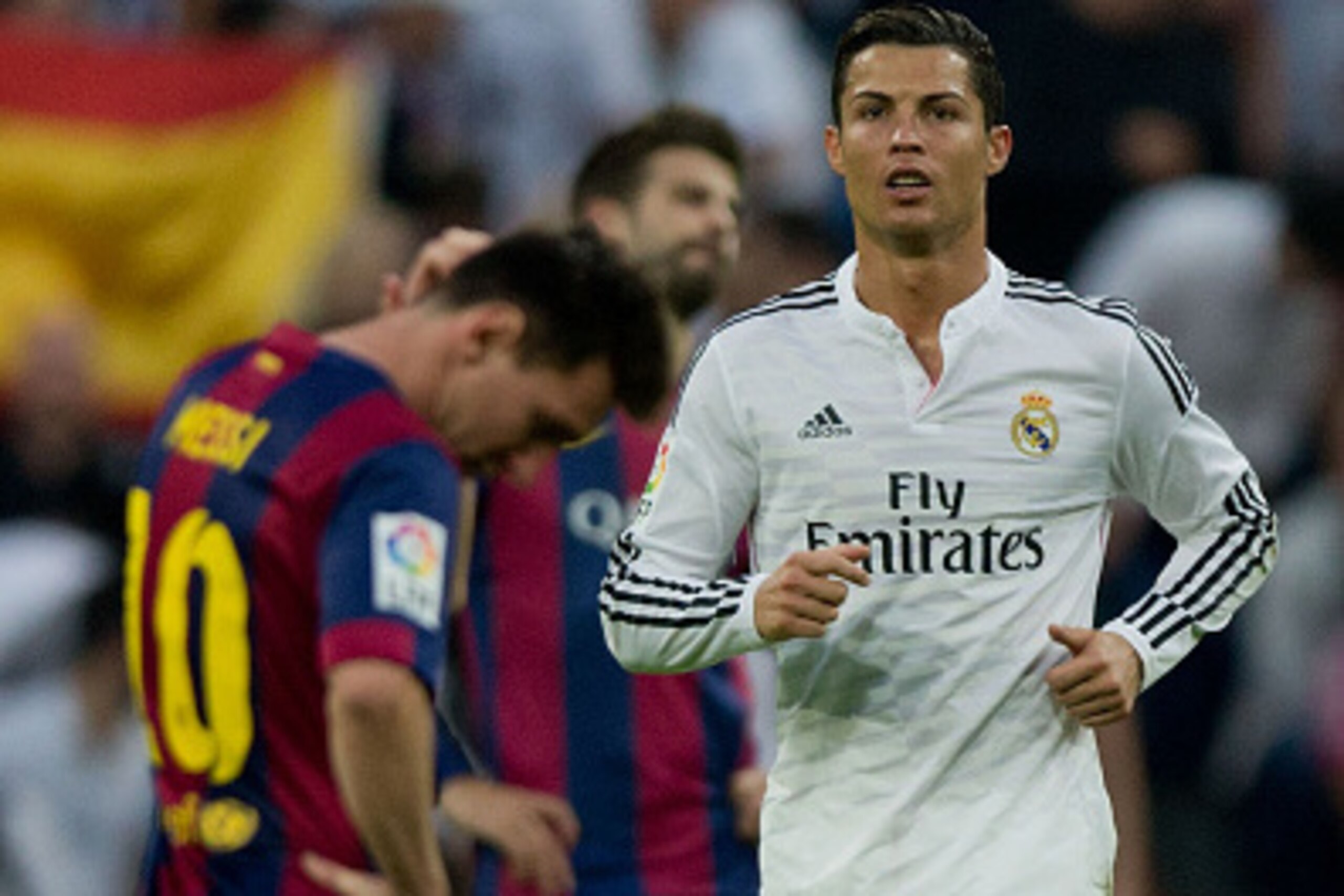 MADRID, SPAIN - OCTOBER 25: Cristiano Ronaldo (R) of Real Madrid CF walks on after celebrating his team's third goal close to Lionel Messi (R) of FC Barcelonar reacting defeated  during the La Liga match between Real Madrid CF and FC Barcelona at Estadio 