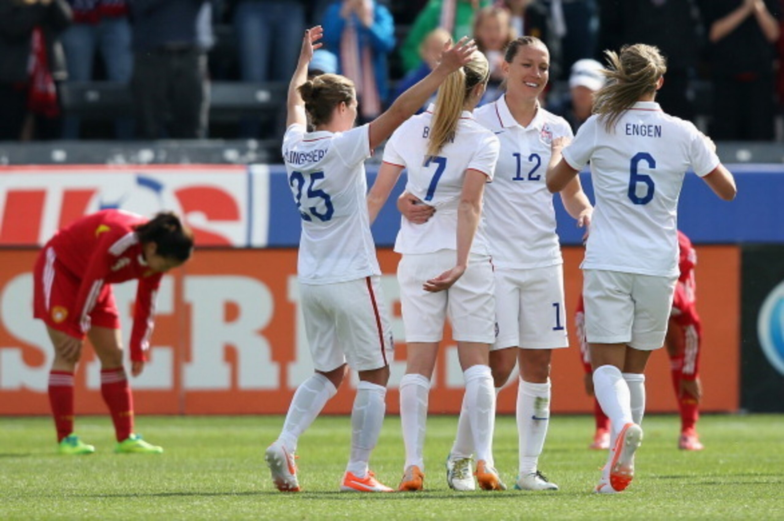 COMMERCE CITY, CO - APRIL 06: Lauren Holiday #12 of the United States celebrates her goal in the first half against China with teammates Meghan Klingenberg #25, Morgan Brian #7 and Whitney Engen #6 at Dick's Sporting Goods Park on April 6, 2014 in Commerc