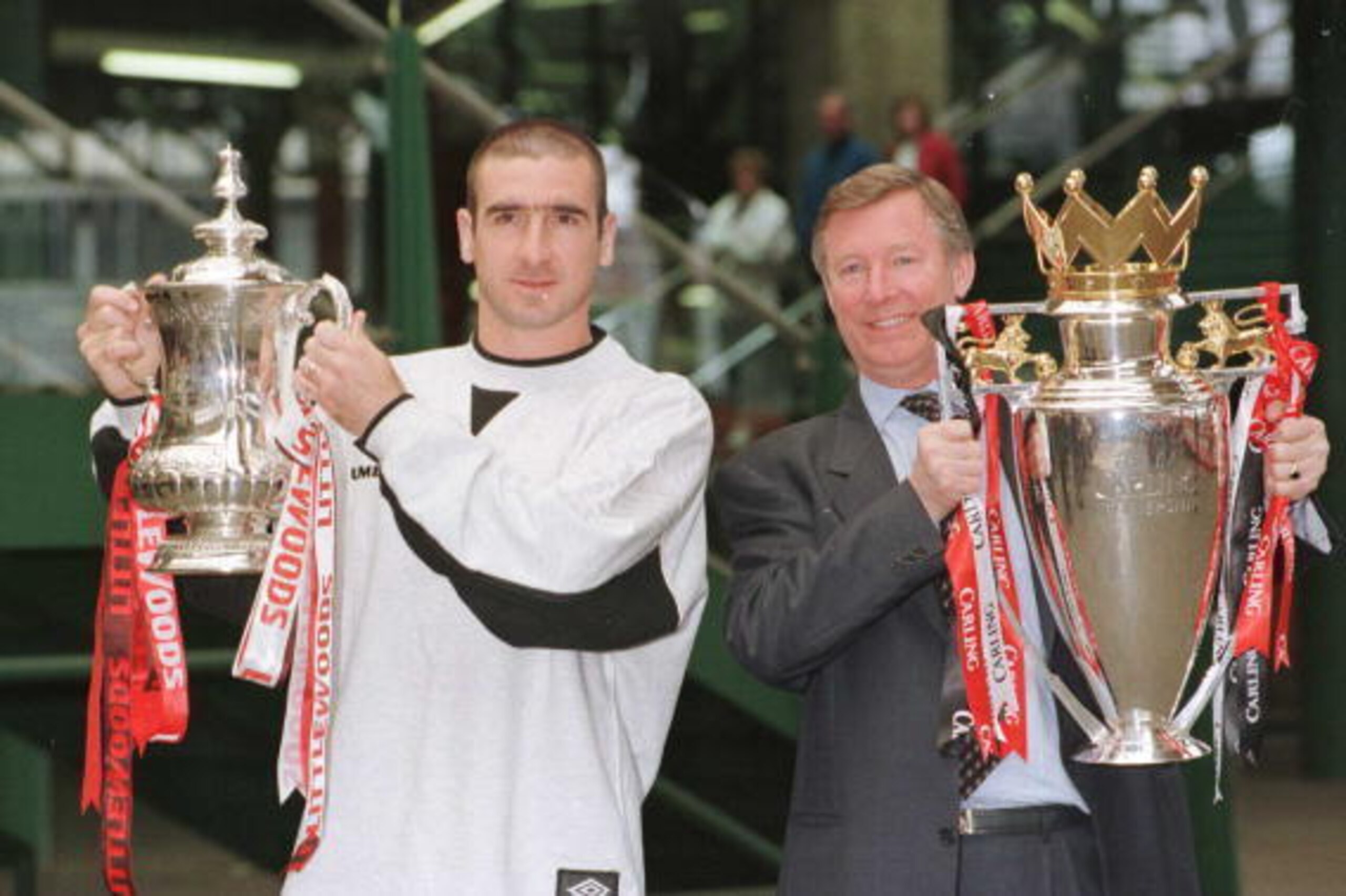 12th May 1996; Manchester United manager Alex Ferguson and Eric Cantona with the FA Cup and Premiership trophy on their arrival at Manchester's Victoria station. Mandatory Credit: Shaun Botterill/ALLSPORT