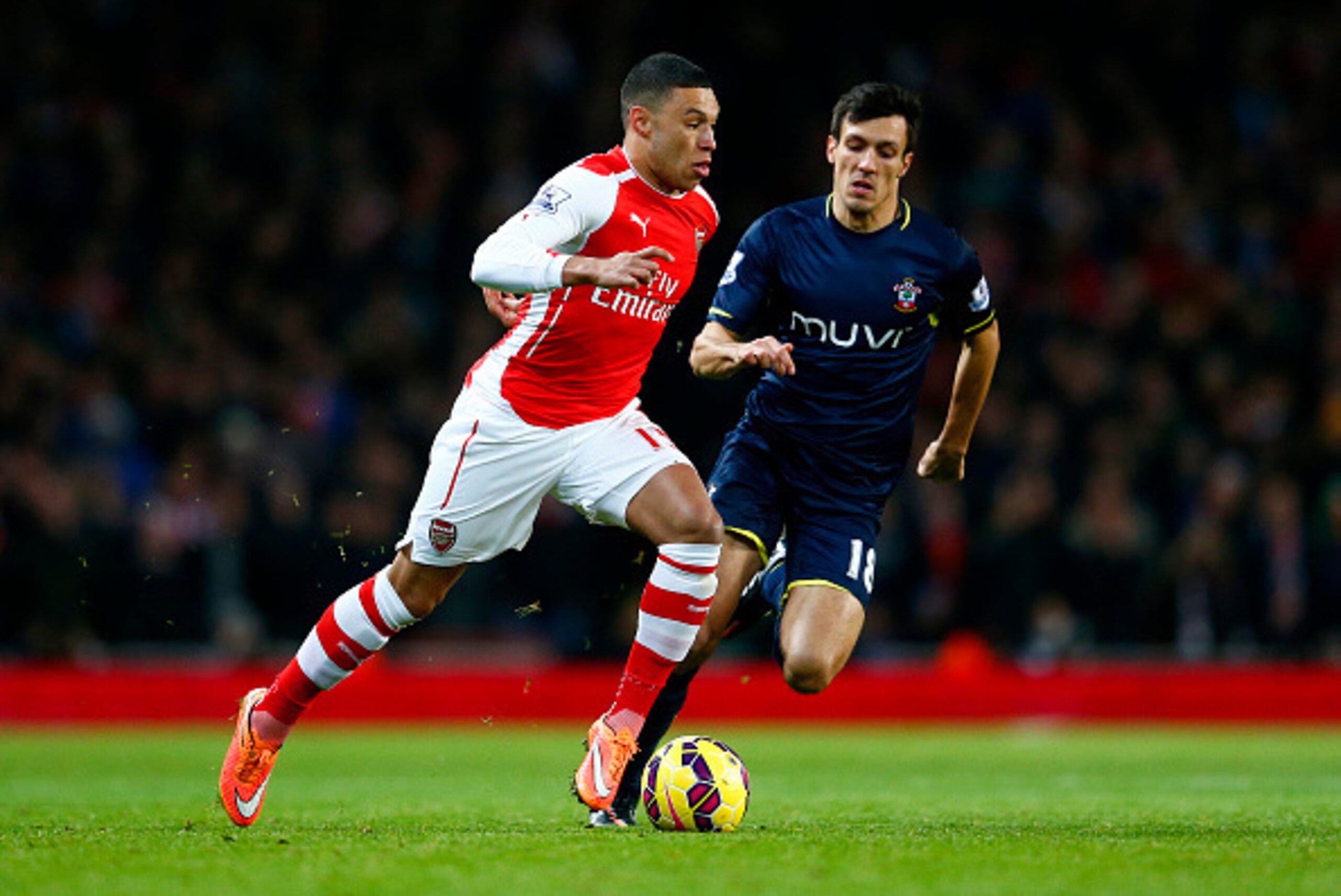 LONDON, ENGLAND - DECEMBER 03:  Alex Oxlade-Chamberlain of Arsenal runs with the ball past Jack Cork of Southampton during the Barclays Premier League match between Arsenal and Southampton at Emirates Stadium on December 3, 2014 in London, England.  (Phot