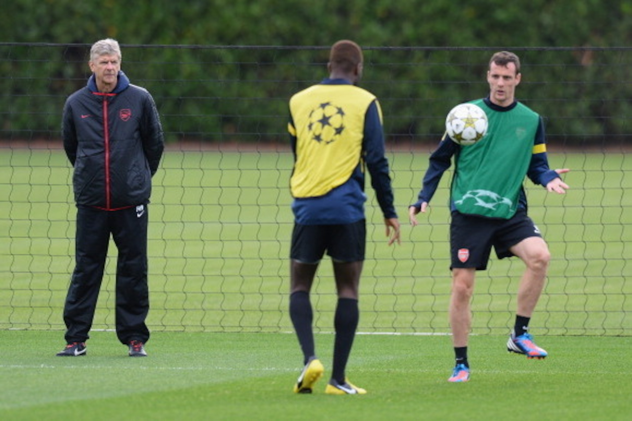 ST ALBANS, ENGLAND - OCTOBER 02:  Arsenal manager Arsene Wenger looks on as Johan Djourou and Sebastien Squillaci practise ball skills during an Arsenal training session ahead of the Uefa Champions League Group B match between Arsenal and Olympiacos at Lo