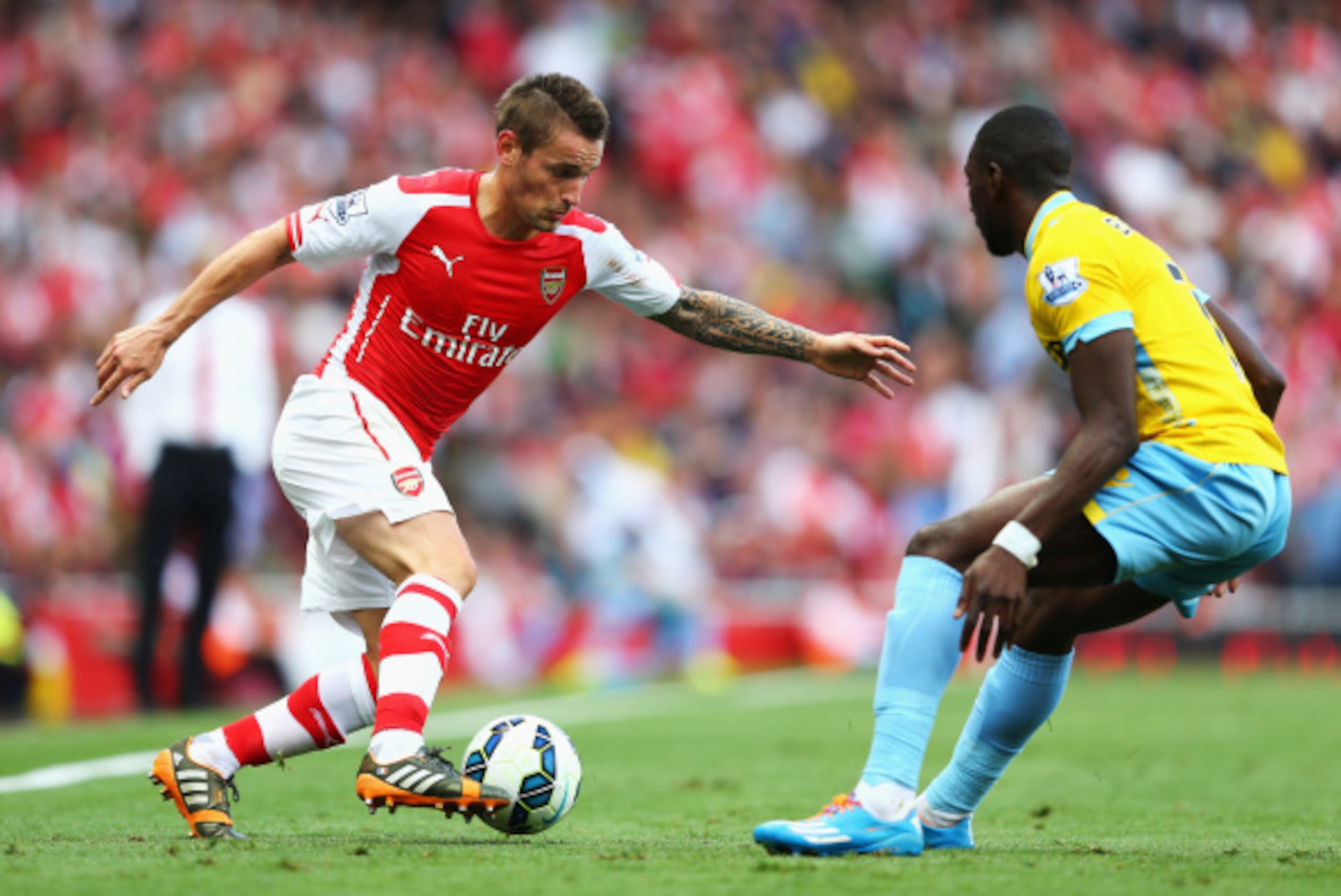 LONDON, ENGLAND - AUGUST 16: Mathieu Debuchy of Arsenal takes on Yannick Bolasie of Crystal Palace during the Barclays Premier League match between Arsenal and Crystal Palace at Emirates Stadium on August 16, 2014 in London, England.  (Photo by Clive Maso