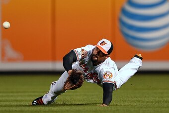 BALTIMORE, MD - SEPTEMBER 15: Right fielder Nick Markakis #21 of the Baltimore Orioles makes a catch on John Mayberry Jr. #9 of the Toronto Blue Jays (not pictured) in the first inning at Oriole Park at Camden Yards on September 15, 2014 in Baltimore, Mar