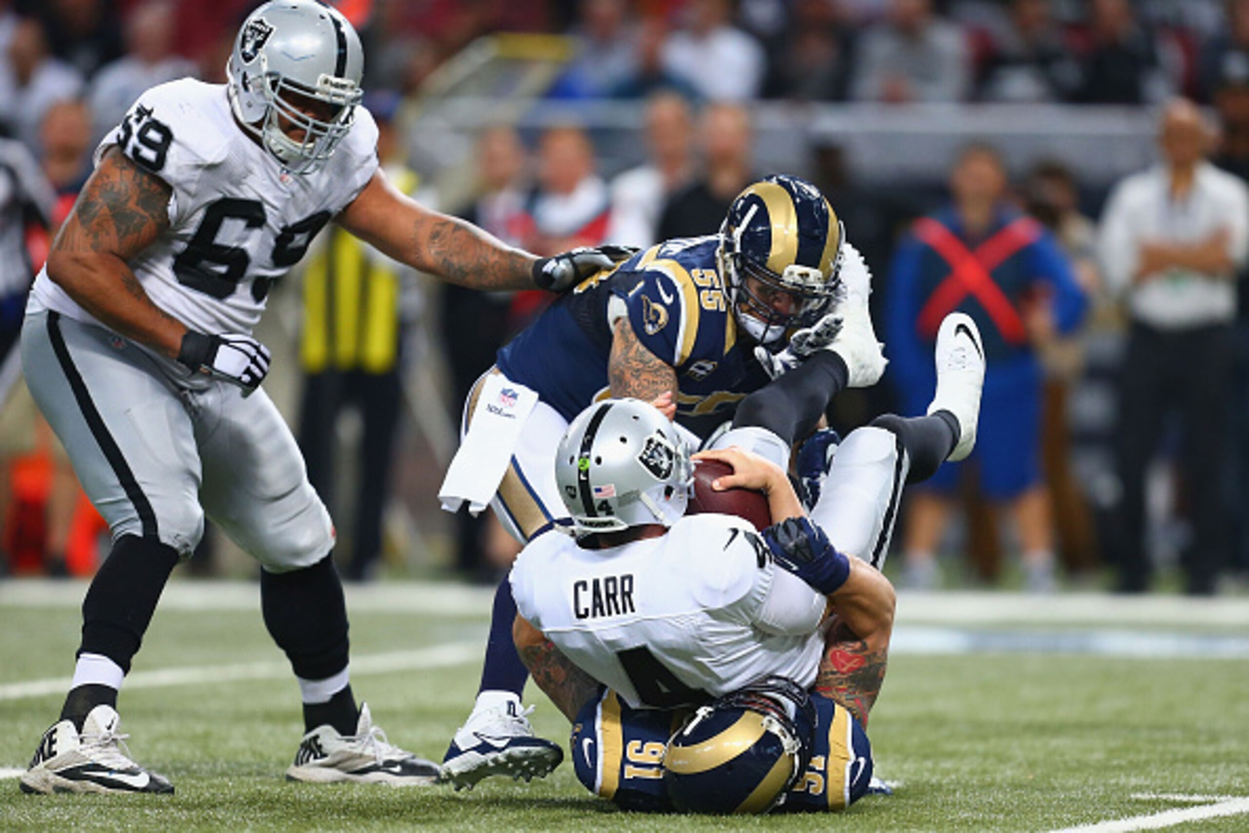 ST. LOUIS, MO - NOVEMBER 30: Derek Carr #4 of the Oakland Raiders is sacked by James Laurinaitis #55 and Chris Long #91 of the St. Louis Rams in the third quarter at the Edward Jones Dome on November 30, 2014 in St. Louis, Missouri.  The Rams beat the Rai
