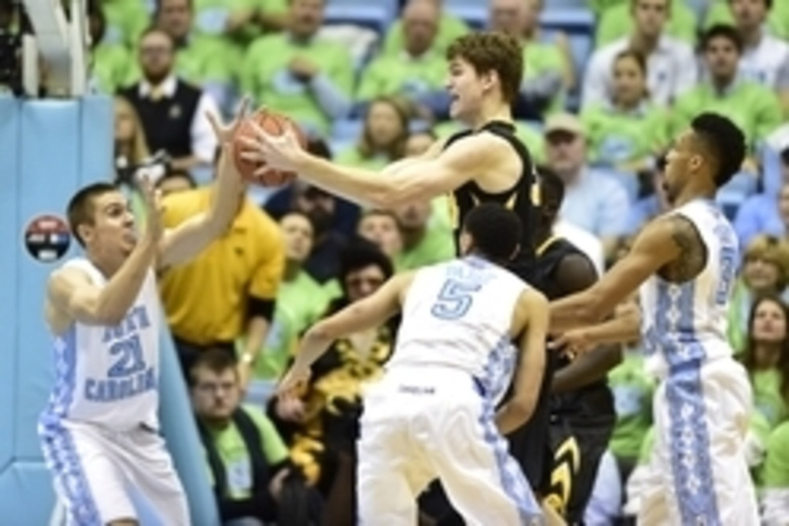 Dec 3, 2014; Chapel Hill, NC, USA; Iowa Hawkeyes center Adam Woodbury (34) with the ball as North Carolina Tar Heels forward Jackson Simmons (21) and guard Marcus Paige (5) and forward J.P. Tokoto (13) defend in the second half. The Iowa Hawkeyes defeated