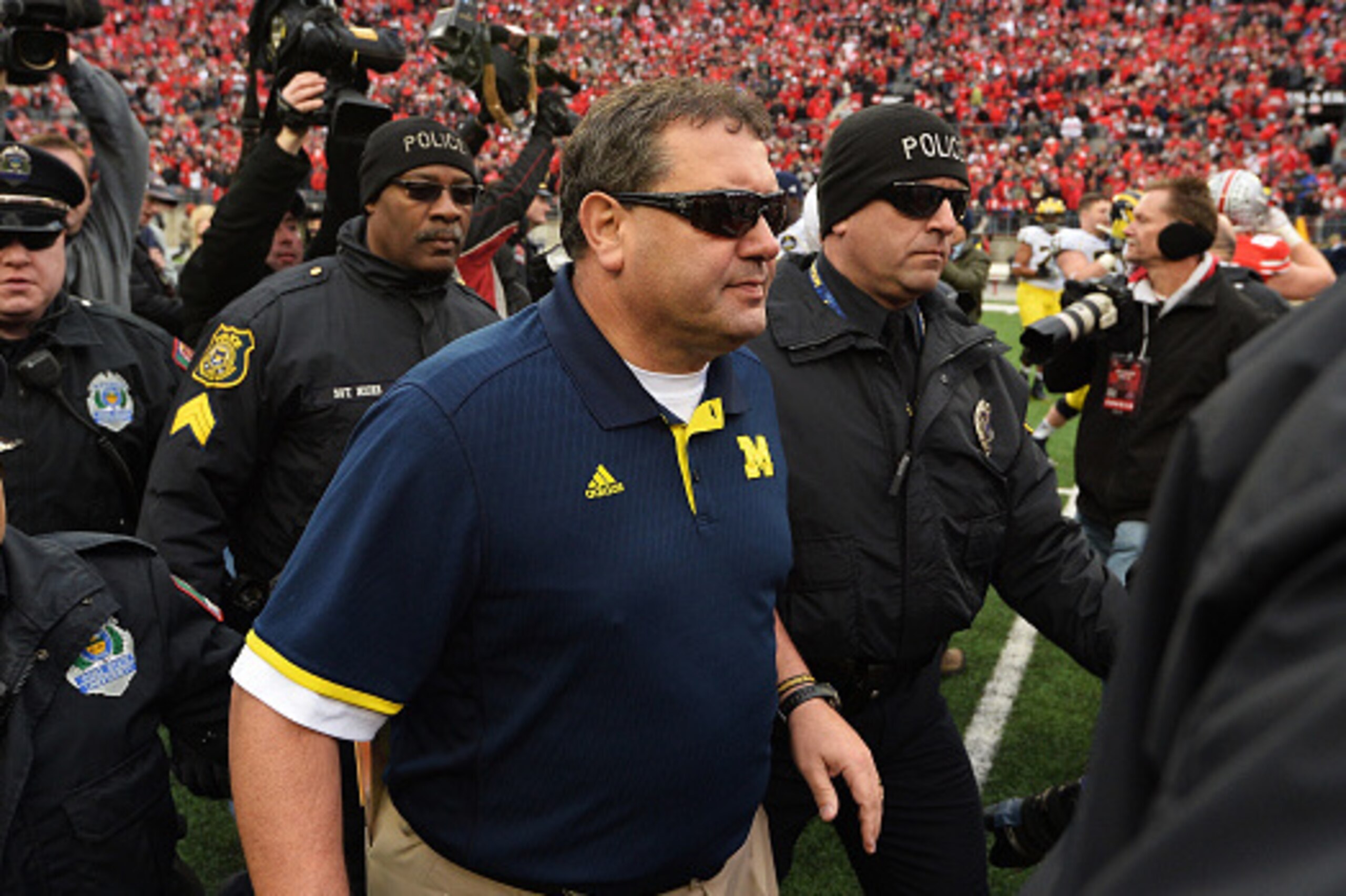 COLUMBUS, OH - NOVEMBER 29:  Head Coach Brady Hoke of the Michigan Wolverines is led off the field by security after his Wolverines lost to Ohio State 42-28 at Ohio Stadium on November 29, 2014 in Columbus, Ohio.   (Photo by Jamie Sabau/Getty Images)