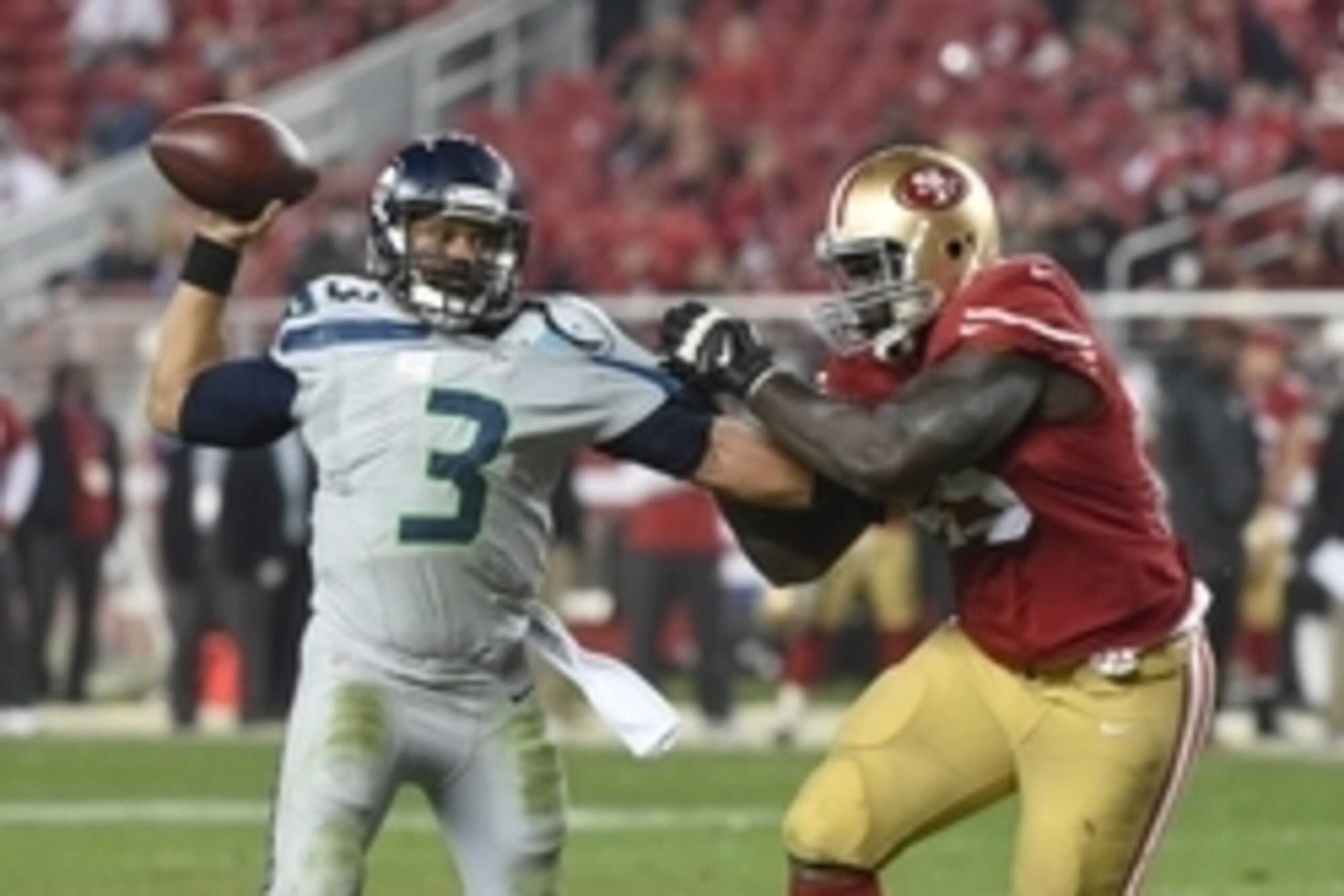 November 27, 2014; Santa Clara, CA, USA; Seattle Seahawks quarterback Russell Wilson (3) passes the football against San Francisco 49ers defensive end Tank Carradine (95) during the fourth quarter at Levi's Stadium. The Seahawks defeated the 49ers 19-3. M