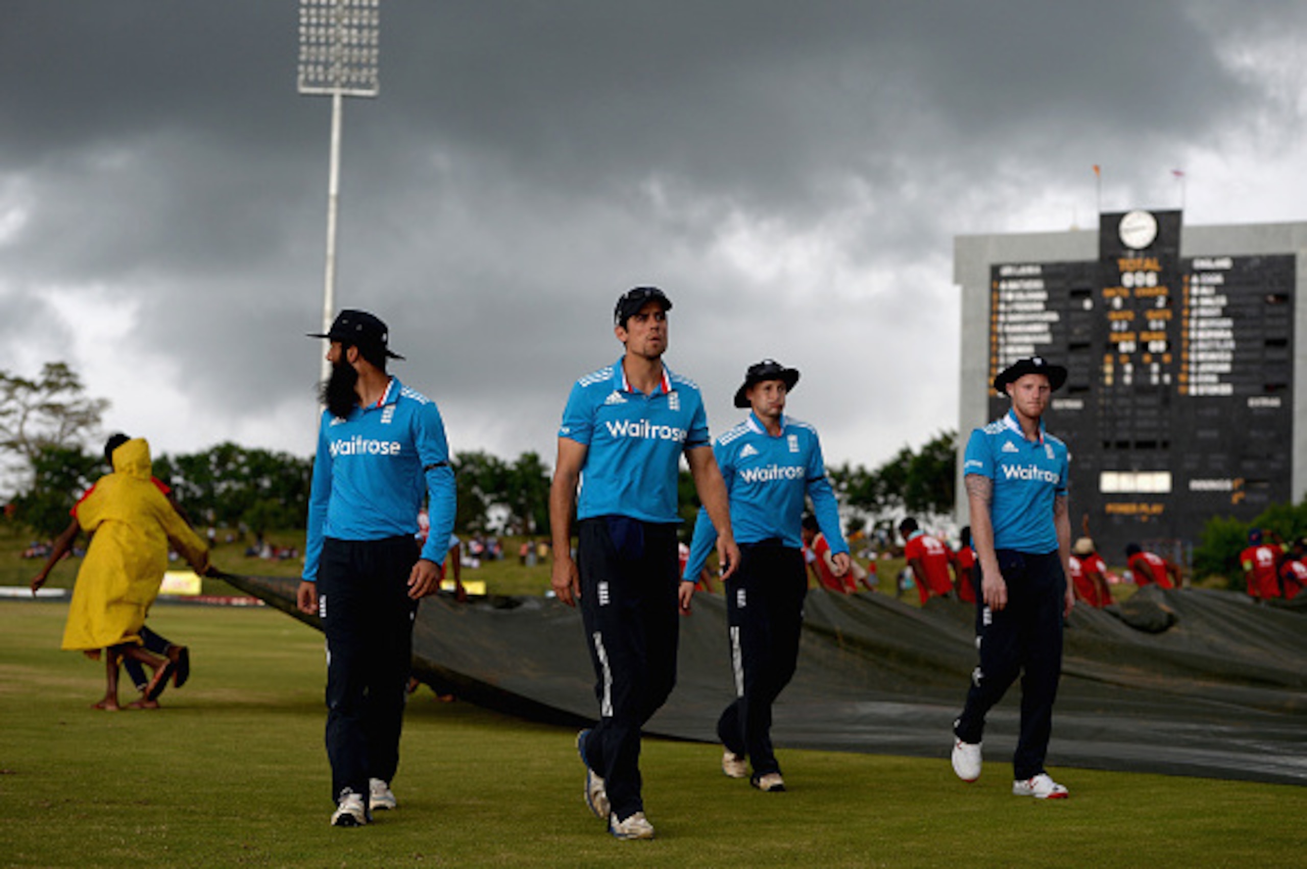 HAMBANTOTA, SRI LANKA - DECEMBER 03:  England captain Alastair Cook leads his players from the field as rain stops play during the 3rd One Day International between Sri Lanka and England at Mahinda Rajapaksa International Stadium on December 3, 2014 in Ha