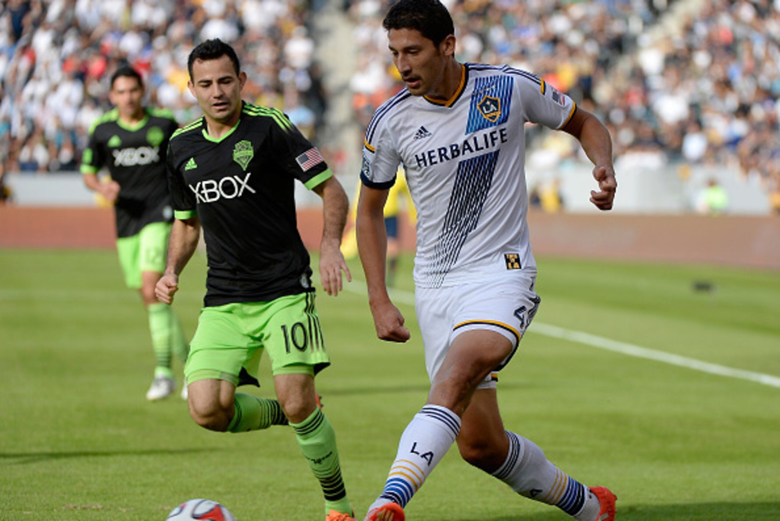 LOS ANGELES, CA - NOVEMBER 23:  Omar Gonzalez #4 of Los Angeles Galaxy looks to pass as he is chased by Marco Pappa #10 of Seattle Sounders FC during the Western Conference Final at StubHub Center on November 23, 2014 in Los Angeles, California.  (Photo b