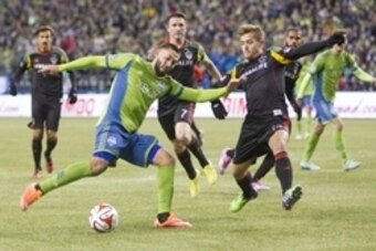 Nov 30, 2014; Seattle, WA, USA; Seattle Sounders FC forward Clint Dempsey (2) gets off a shot despite the defense of Los Angeles Galaxy defender Robbie Rogers (14) during the second half of the Western Conference Championship at CenturyLink Field. Mandato