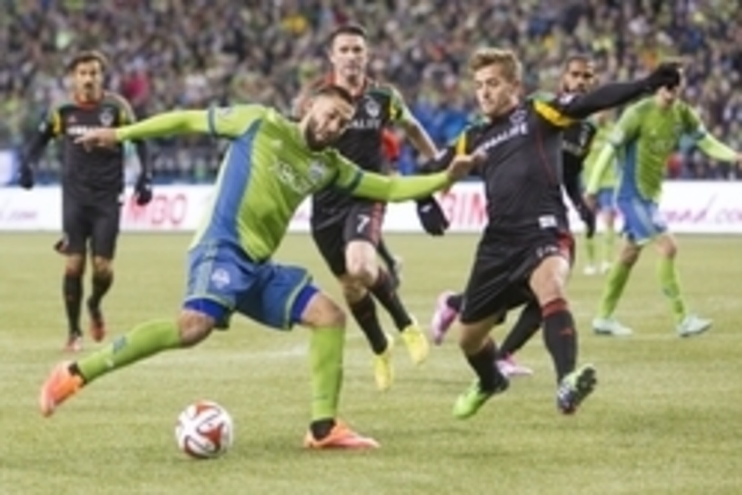 Nov 30, 2014; Seattle, WA, USA; Seattle Sounders FC forward Clint Dempsey (2) gets off a shot despite the defense of Los Angeles Galaxy defender Robbie Rogers (14) during the second half of the Western Conference Championship at CenturyLink Field. Mandato