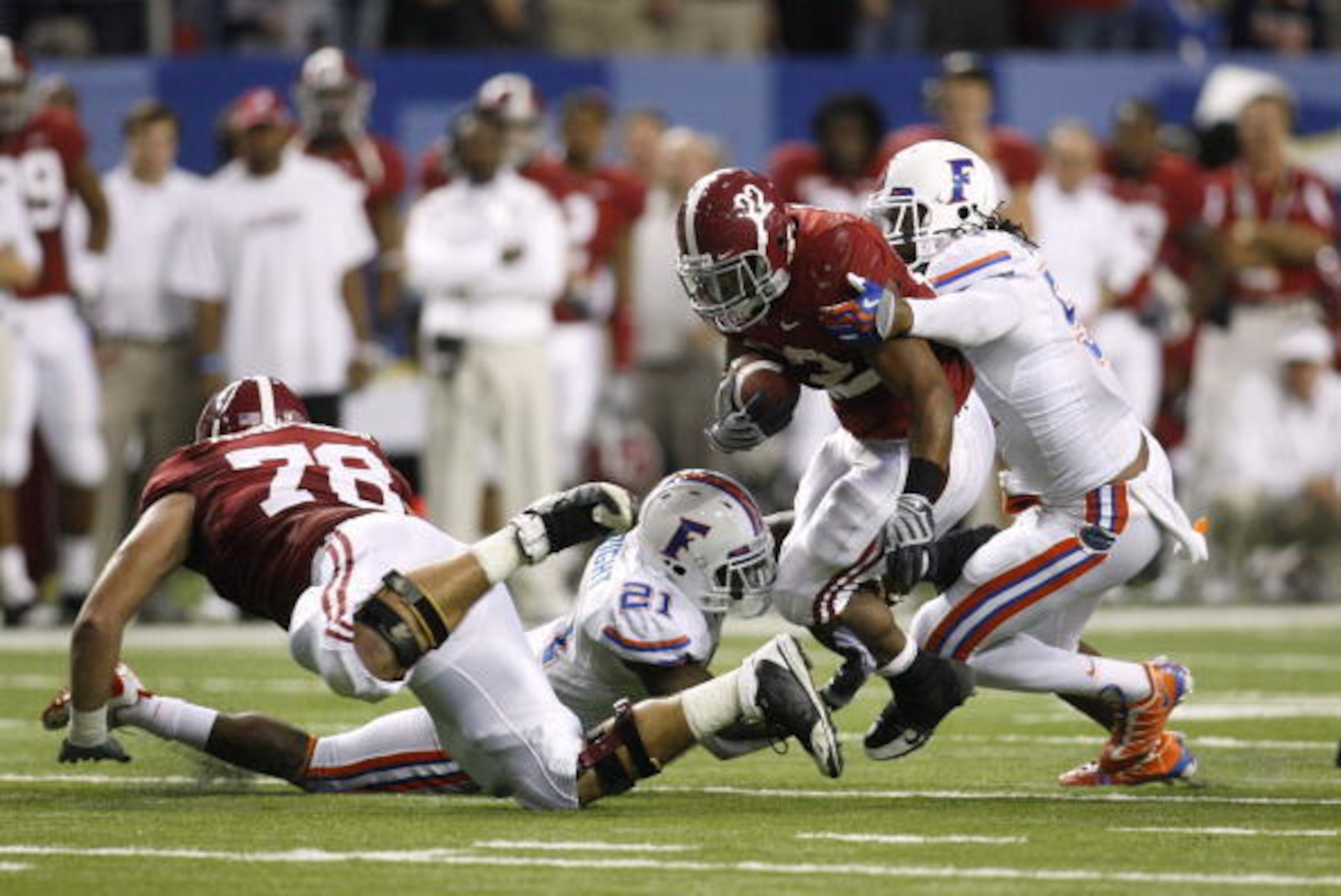 ATLANTA - DECEMBER 5:  Mark Ingram #22 of the Alabama Crimson Tide runs the ball against Major Wright #21 and Brandon Spikes #51 of the Florida Gators during the SEC Championship game at Georgia Dome on December 5, 2009 in Atlanta, Georgia.  (Photo by Chr