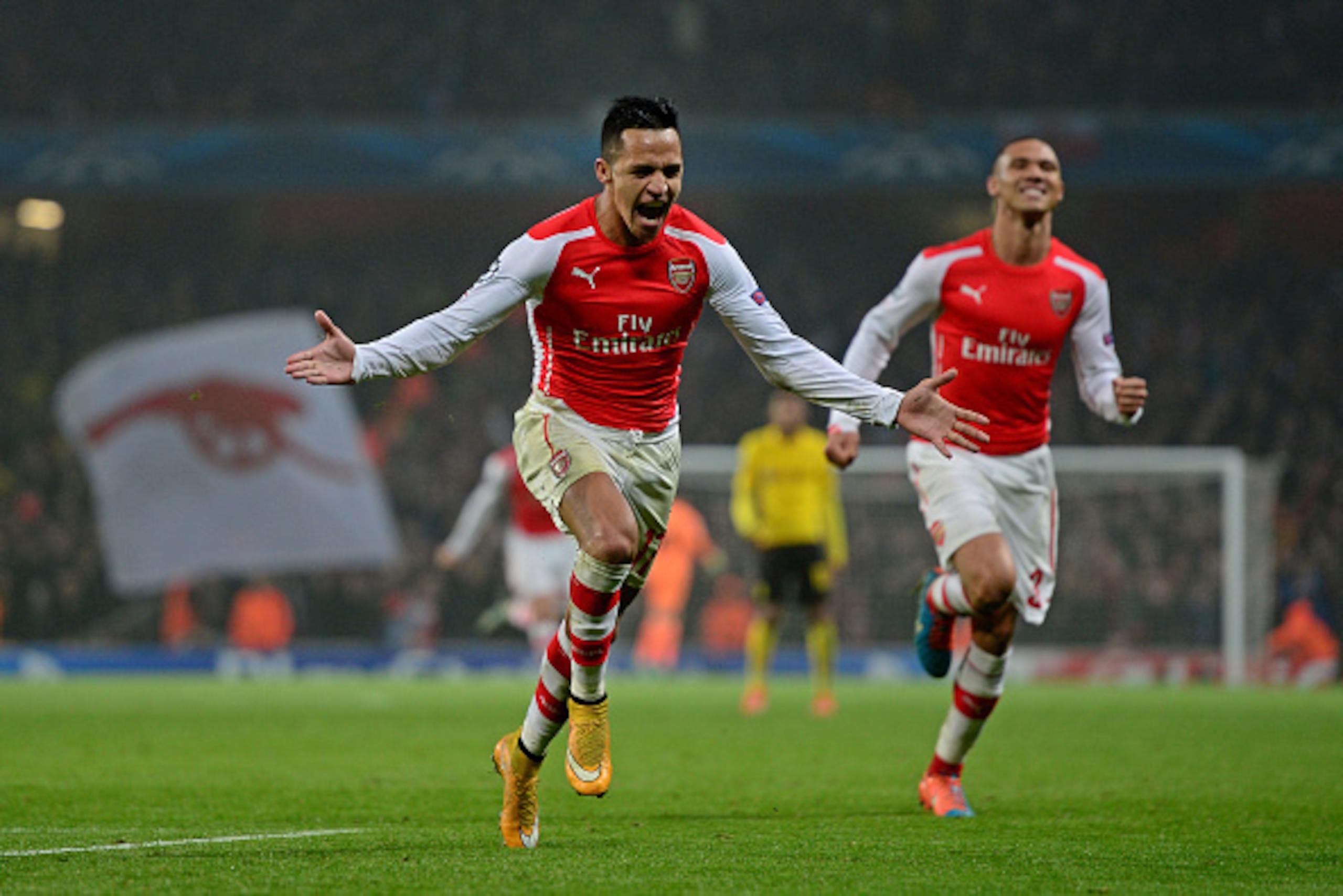 LONDON, ENGLAND - NOVEMBER 26:  Alexis Sanchez of Arsenal celebrates with teammate Kieran Gibbs (R) after scoring his team's second goal during the UEFA Champions League Group D match between Arsenal and Borussia Dortmund at the Emirates Stadium on Novemb