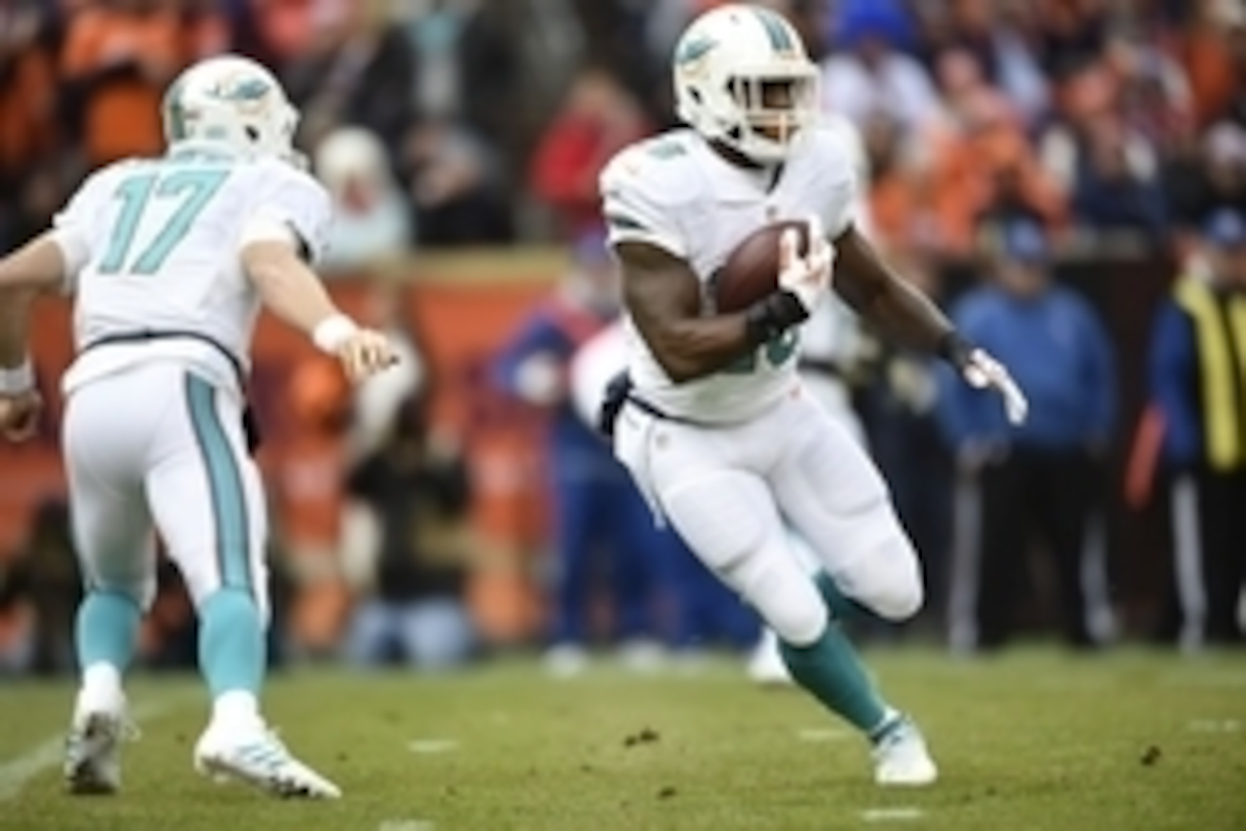 Nov 23, 2014; Denver, CO, USA; Miami Dolphins running back Lamar Miller (26) carries the football in the first quarter against the Denver Broncos at Sports Authority Field at Mile High. Mandatory Credit: Ron Chenoy-USA TODAY Sports