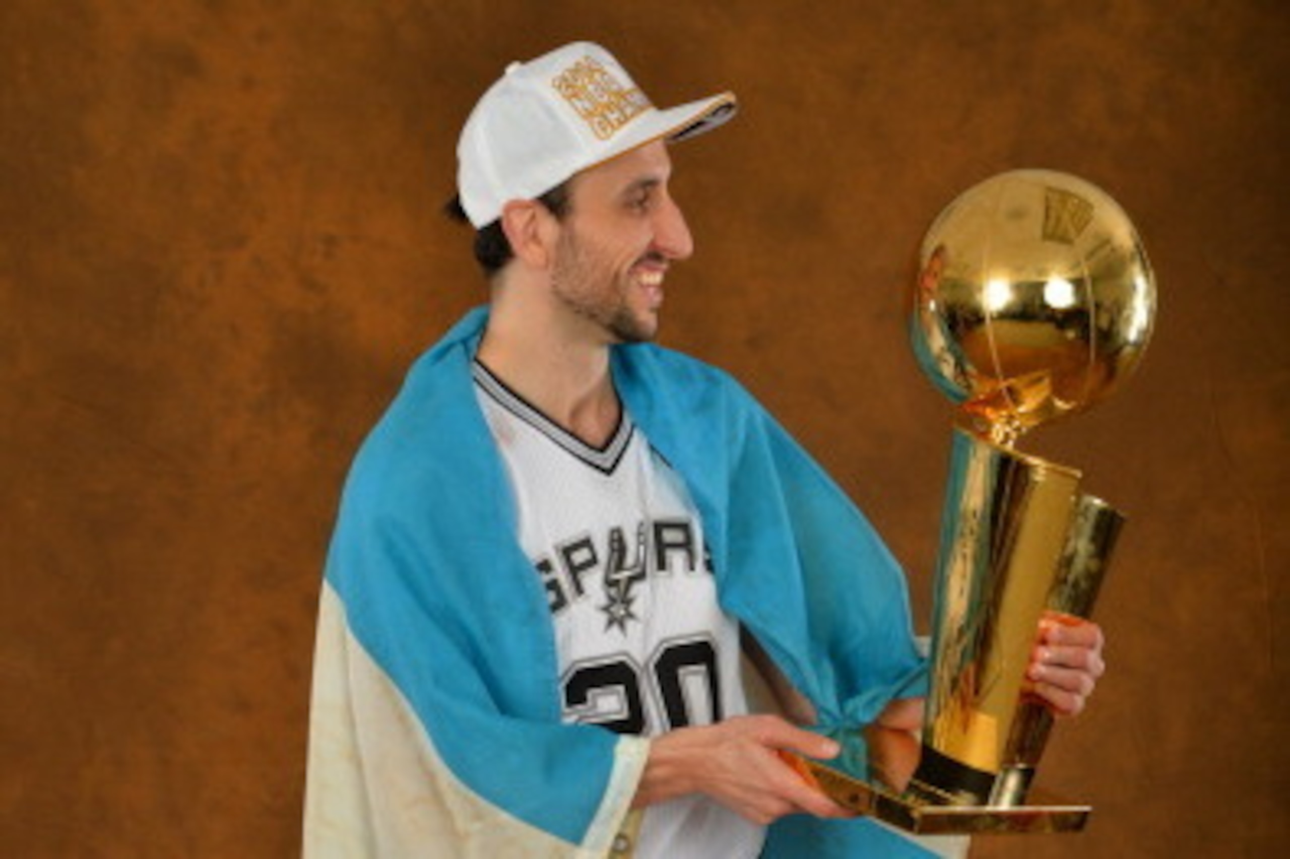 SAN ANTONIO, TX - JUNE 15: Manu Ginobili #20 of the San Antonio Spurs poses for a portrait with the Larry O'Brien Trophy after defeating the Miami Heat in Game Five of the 2014 NBA Finals on June 15, 2014 at AT&T Center in San Antonio, Texas. NOTE TO USER