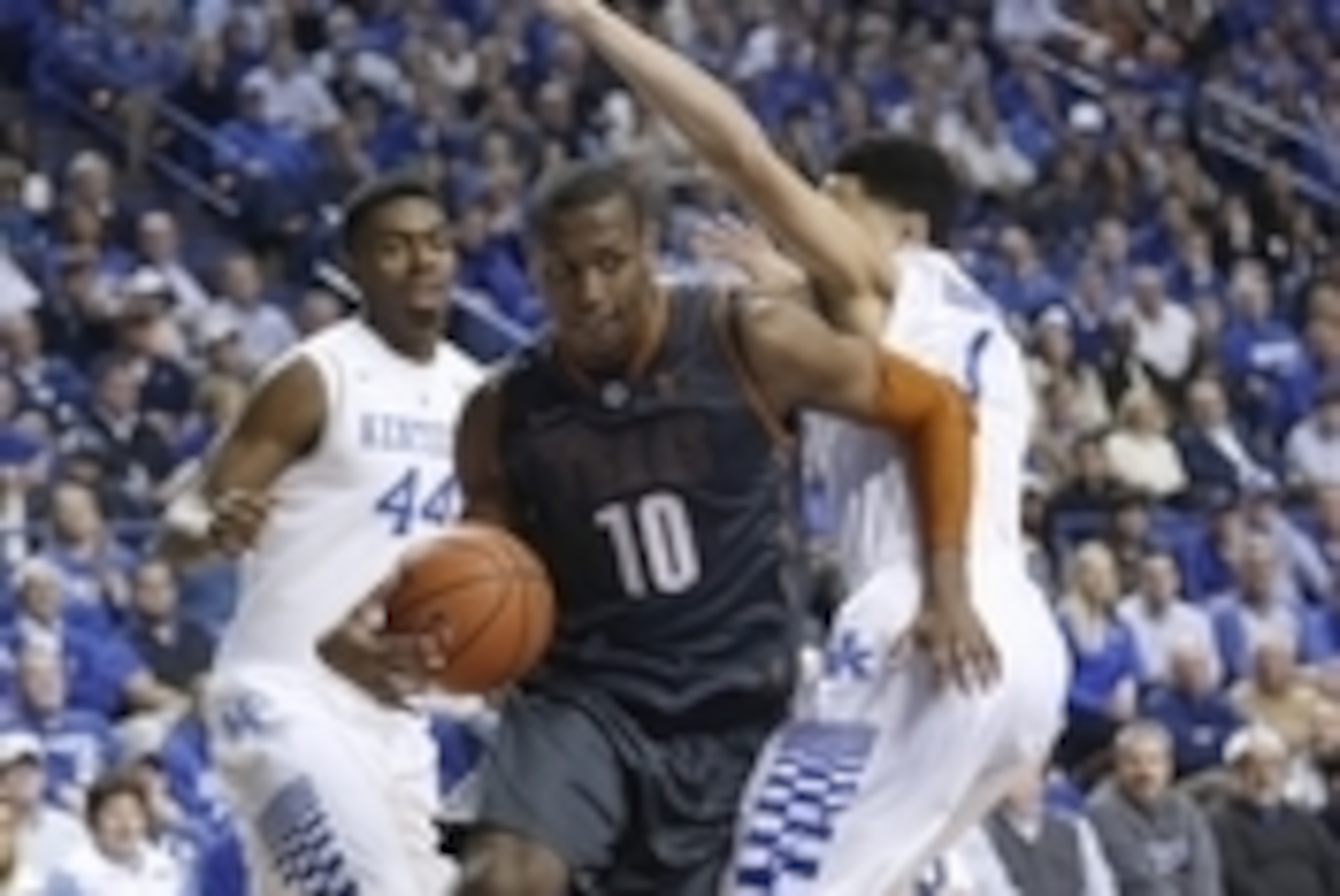 Dec 5, 2014; Lexington, KY, USA; Texas Longhorns forward Jonathan Holmes (10) dribbles the ball against Kentucky Wildcats guard Devin Booker (1) and center Dakari Johnson (44) in the first half at Rupp Arena. Mandatory Credit: Mark Zerof-USA TODAY Sports