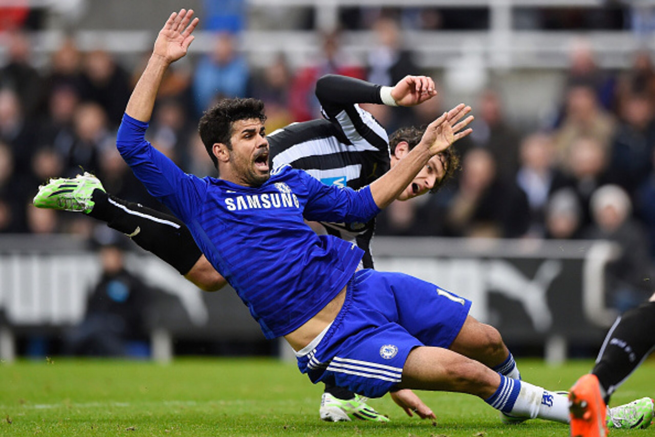 NEWCASTLE UPON TYNE, ENGLAND - DECEMBER 06:  Diego Costa of Chelsea goes down under pressure from Fabricio Coloccini of Newcastle United during the Barclays Premier League match between Newcastle United and Chelsea at St James' Park on December 6, 2014 in
