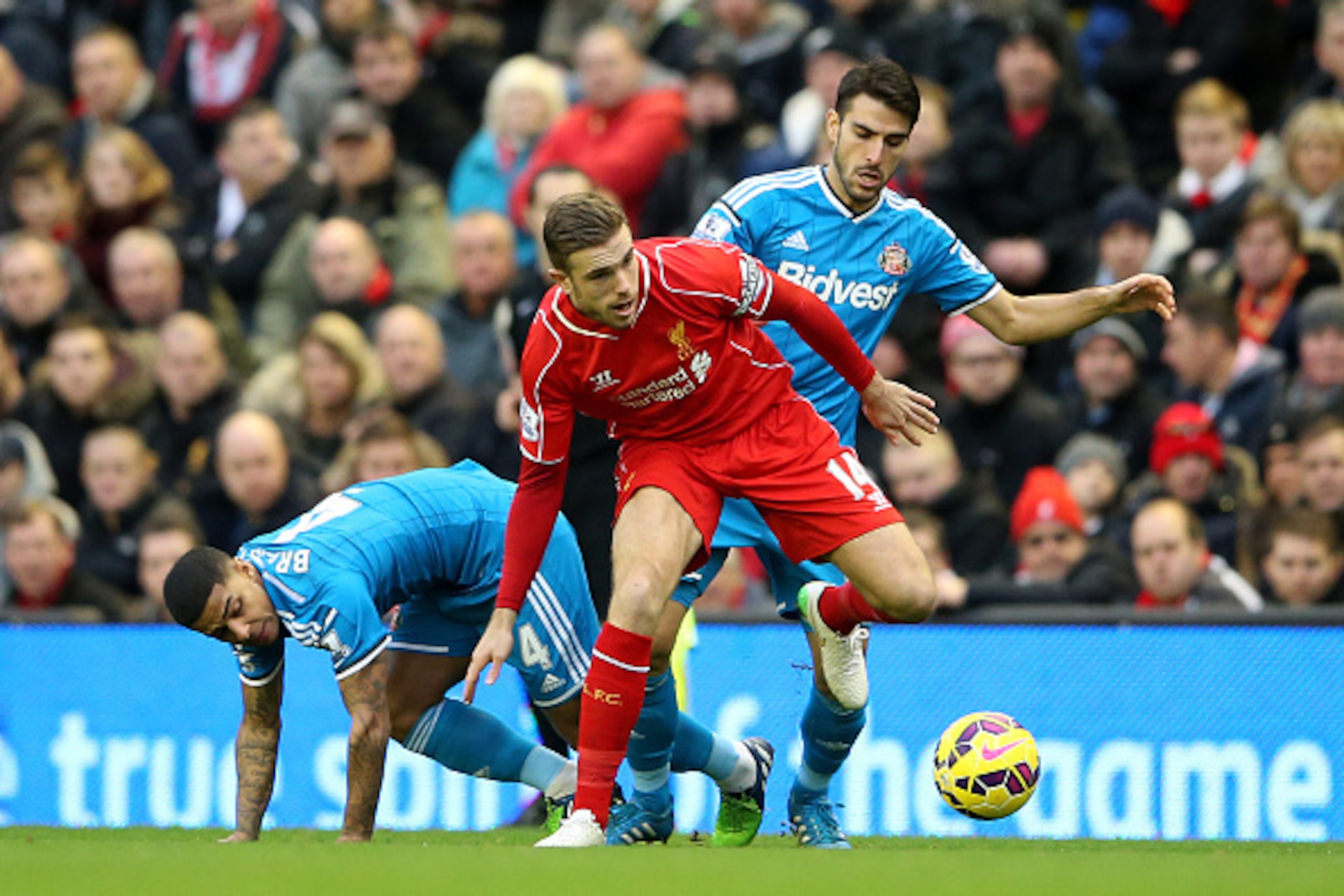 LIVERPOOL, ENGLAND - DECEMBER 06:  Jordan Henderson of Liverpool battles for the ball with Jordi Gomez and Liam Bridcutt of Sunderland during the Barclays Premier League match between Liverpool and Sunderland at Anfield on December 6, 2014 in Liverpool, E