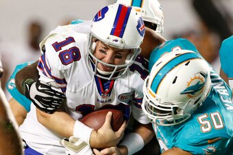MIAMI GARDENS, FL - NOVEMBER 13:  Quarterback Kyle Orton #18 of the Buffalo Bills is brought down by defensive end Olivier Vernon #50 of the Miami Dolphins in the fourth quarter in a game at Sun Life Stadium on November 13, 2014 in Miami Gardens, Florida.