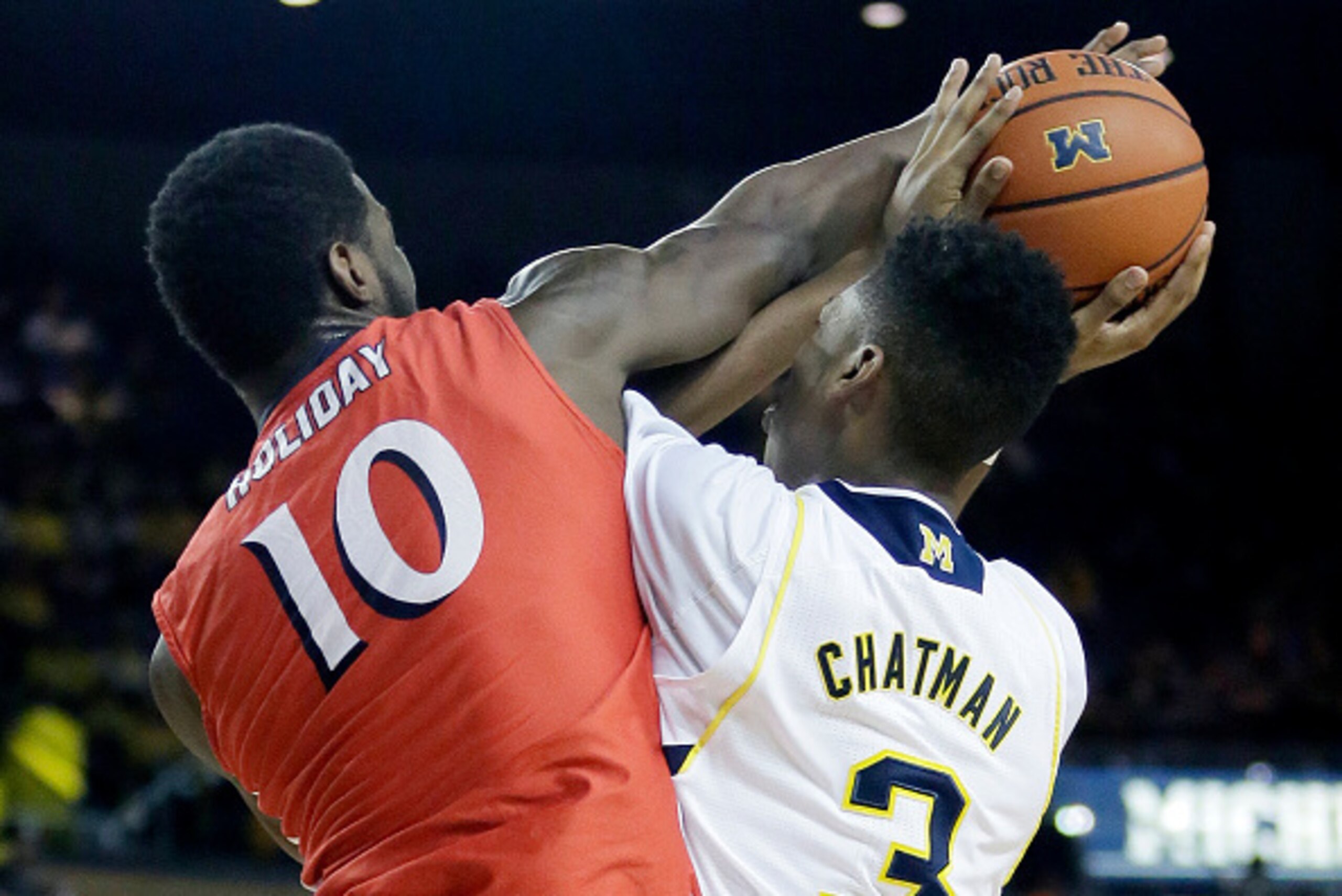 ANN ARBOR, MI - DECEMBER 6:  Daquan Holiday #10 of the New Jersey Institute of Technology Highlanders fouls Kameron Chatman #3 of the Michigan Wolverines while trying to block a shot during the first half at Crisler Arena on December 6, 2014 in Ann Arbor,