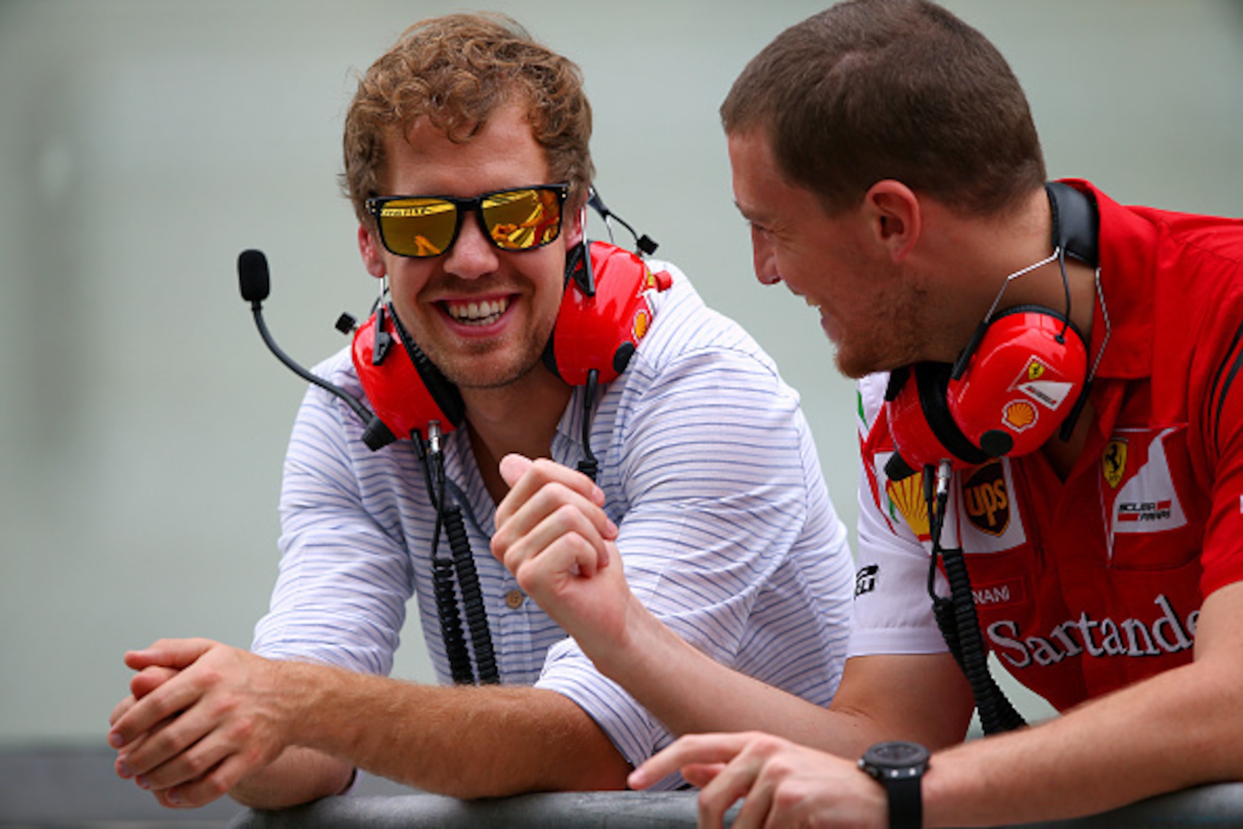 ABU DHABI, UNITED ARAB EMIRATES - NOVEMBER 25:  Sebastian Vettel of Germany and Infiniti Red Bull Racing smiles as he speaks with members of the Ferrari team on the pit wall during day one of Formula One testing at Yas Marina Circuit on November 25, 2014 