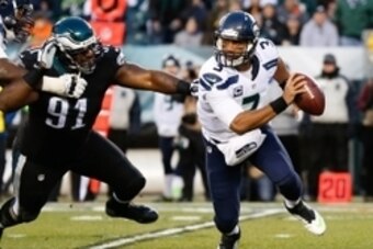 Dec 7, 2014; Philadelphia, PA, USA; Seattle Seahawks quarterback Russell Wilson (3) eludes the pass rush of Philadelphia Eagles defensive end Fletcher Cox (91) during the first quarter at Lincoln Financial Field. Mandatory Credit: Bill Streicher-USA TODAY