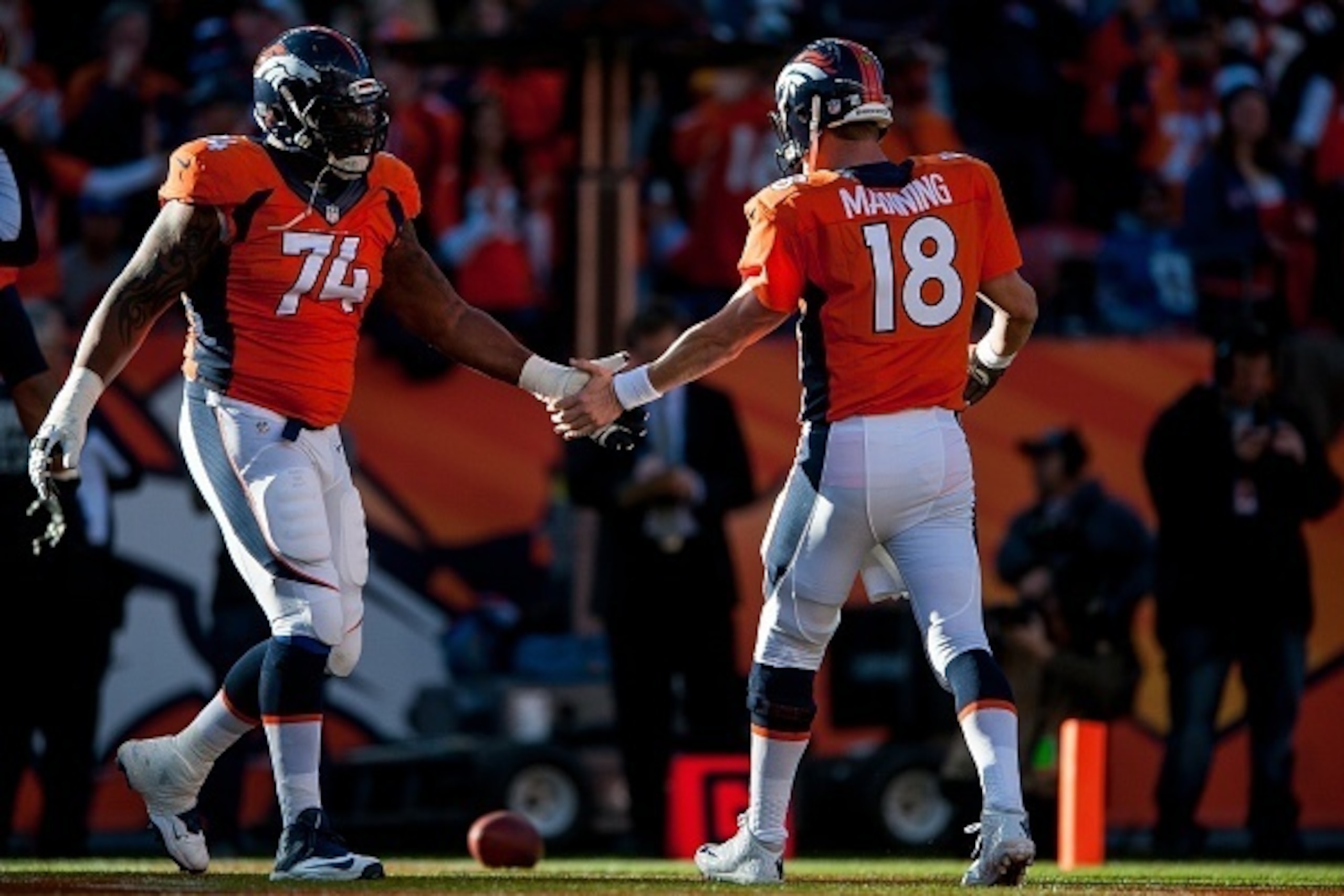 DENVER, CO - DECEMBER 7:  Quarterback Peyton Manning #18 and guard Orlando Franklin #74 of the Denver Broncos celebrate a rushing touchdown during a game against the Buffalo Bills at Sports Authority Field at Mile High on December 7, 2014 in Denver, Color