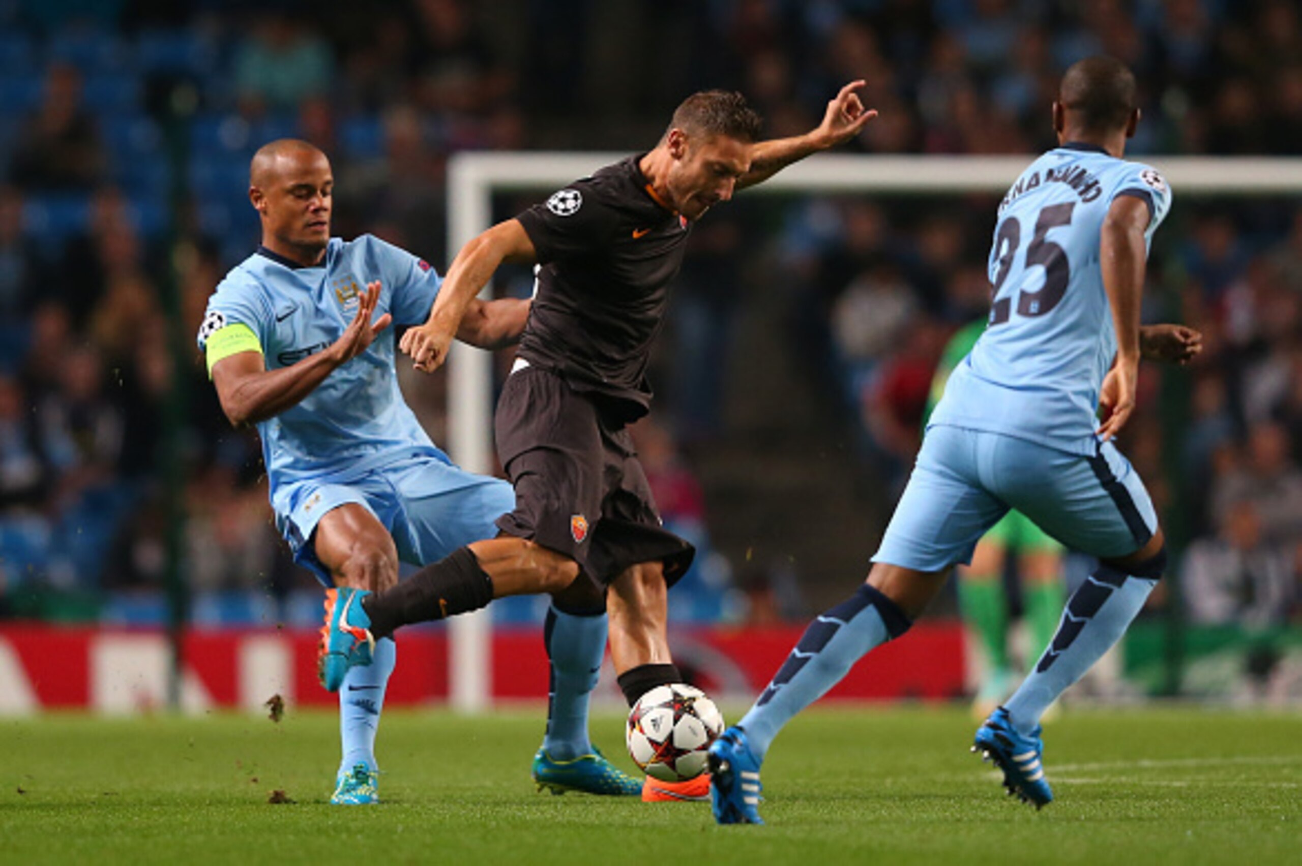 MANCHESTER, ENGLAND - SEPTEMBER 30:  Francesco Totti of AS Roma is challenged by Vincent Kompany of Manchester City during the UEFA Champions League Group E match between Manchester City FC and AS Roma  on September 30, 2014 in Manchester, United Kingdom.