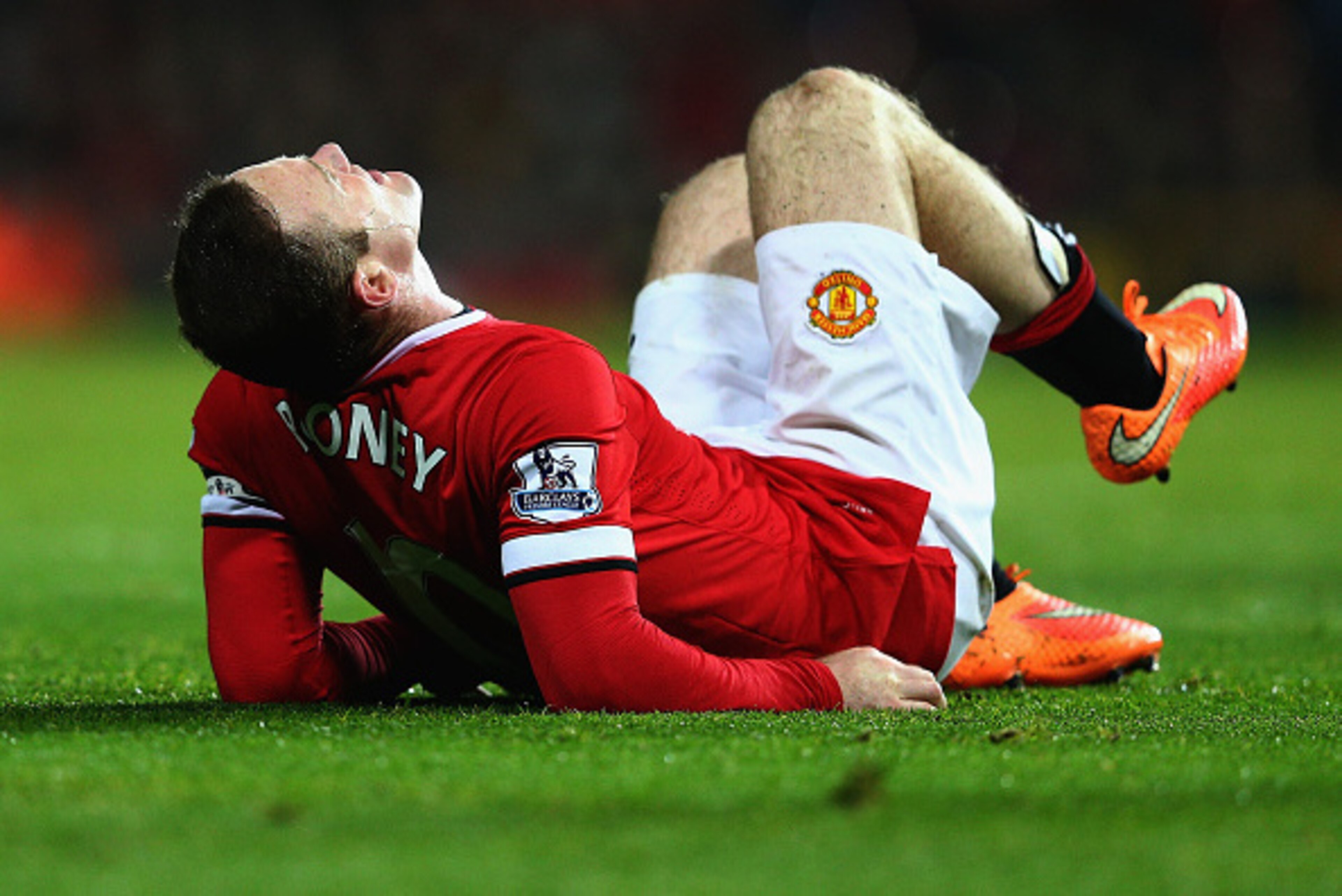 MANCHESTER, ENGLAND - NOVEMBER 29: Wayne Rooney of Manchester United lies injured during the Barclays Premier League match between Manchester United and Hull City at Old Trafford on November 29, 2014 in Manchester, England.  (Photo by Clive Mason/Getty Im