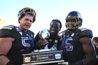 Dec 31, 2013; El Paso, TX, USA; UCLA Bruins center Carl Hulick (57) and defensive end Owamagbe Odighizuwa (94) and linebacker Kenny Orjioke (46) hold the 2013 Sun Bowl trophy at Sun Bowl Stadium. UCLA defeated Virginia Tech 42-12. Mandatory Credit: Andrew