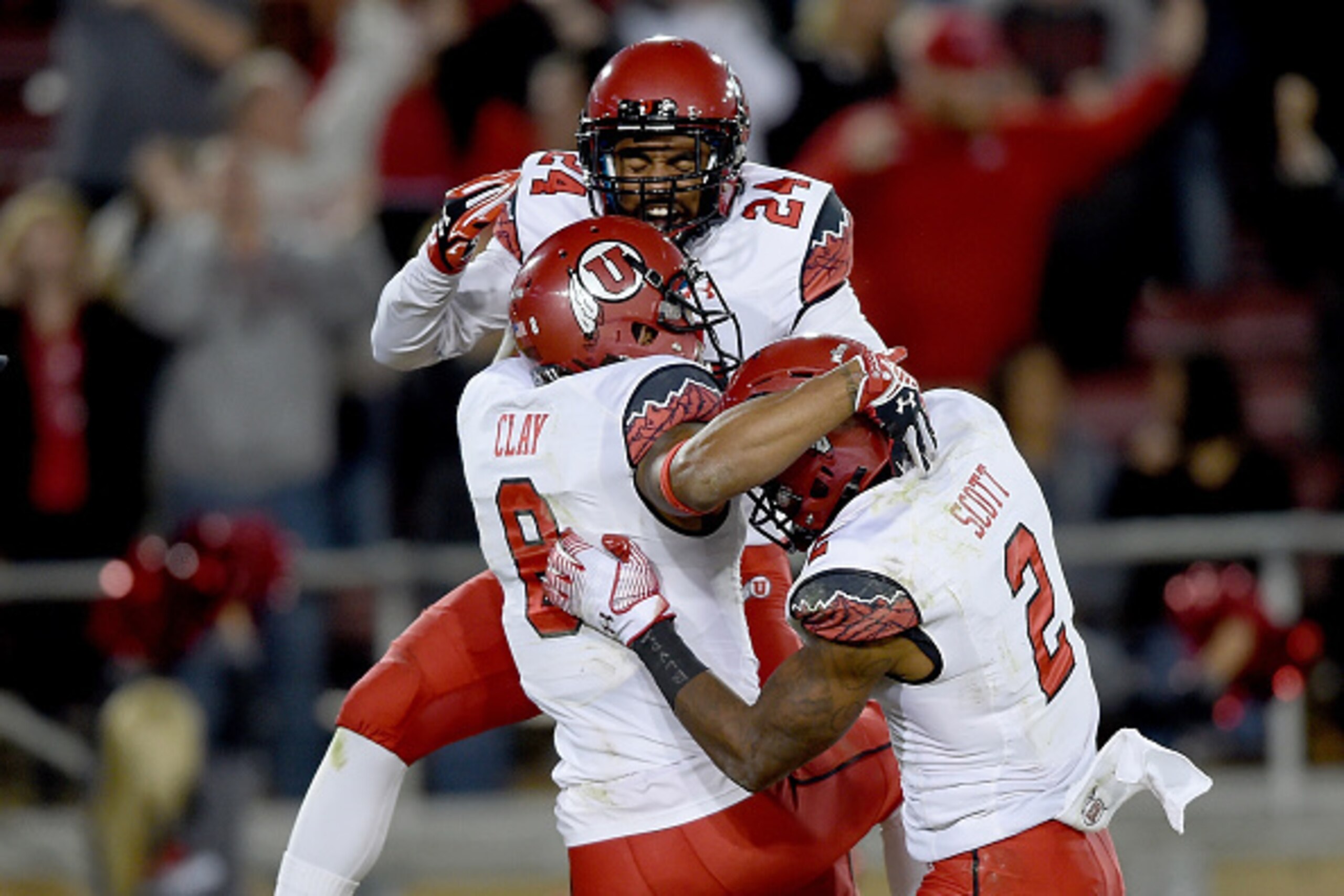 PALO ALTO, CA - NOVEMBER 15:  Kevin Clay #8, Kenric Young #24 and Kenneth Scott #2 of the Utah Utes celebrates after Clay caught a touchdown pass in overtime against the Stanford Cardinal at Stanford Stadium on November 15, 2014 in Palo Alto, California. 