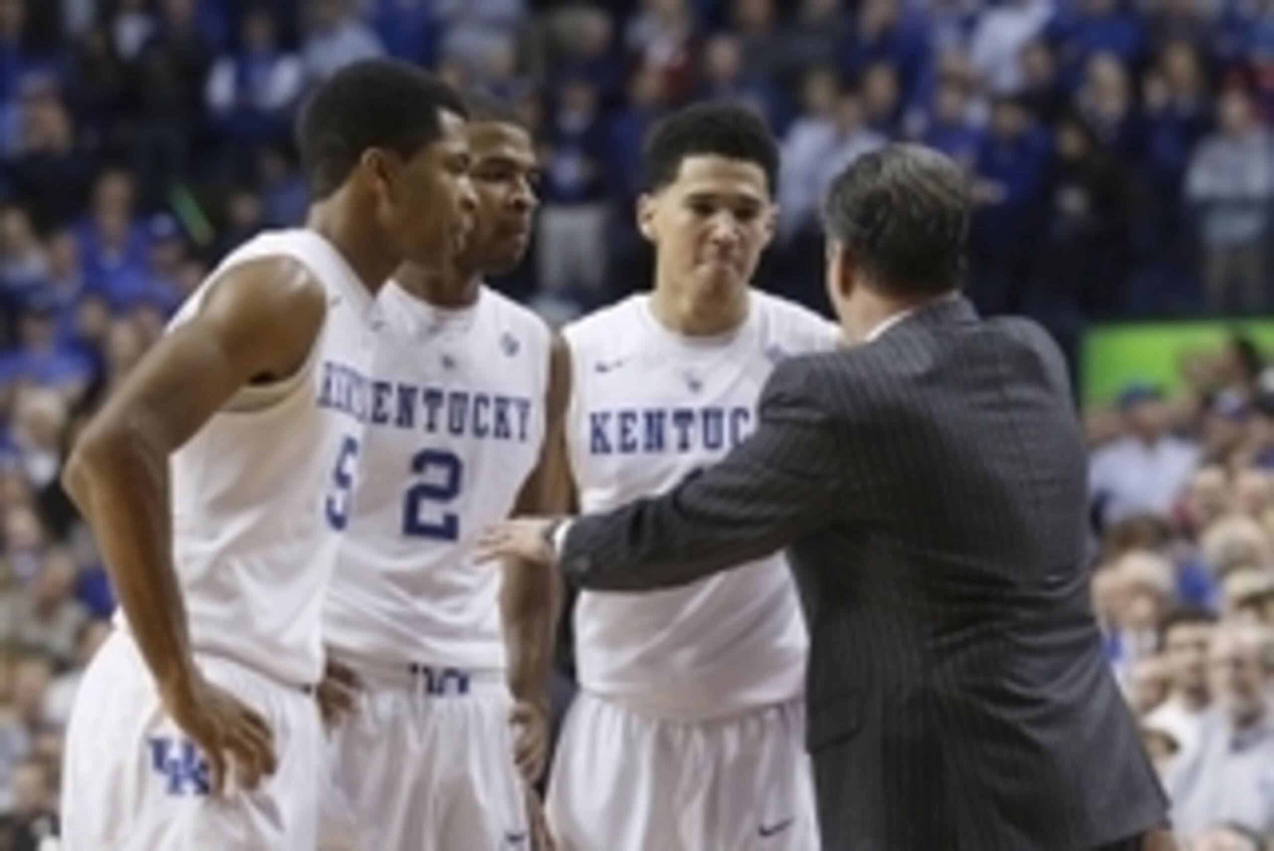 Dec 5, 2014; Lexington, KY, USA; Kentucky Wildcats head coach John Calipari (R) talks with guard Andrew Harrison (5), guard Aaron Harrison (2), and guard Devin Booker (1) during the game against the Texas Longhorns in the second half at Rupp Arena. The Wi