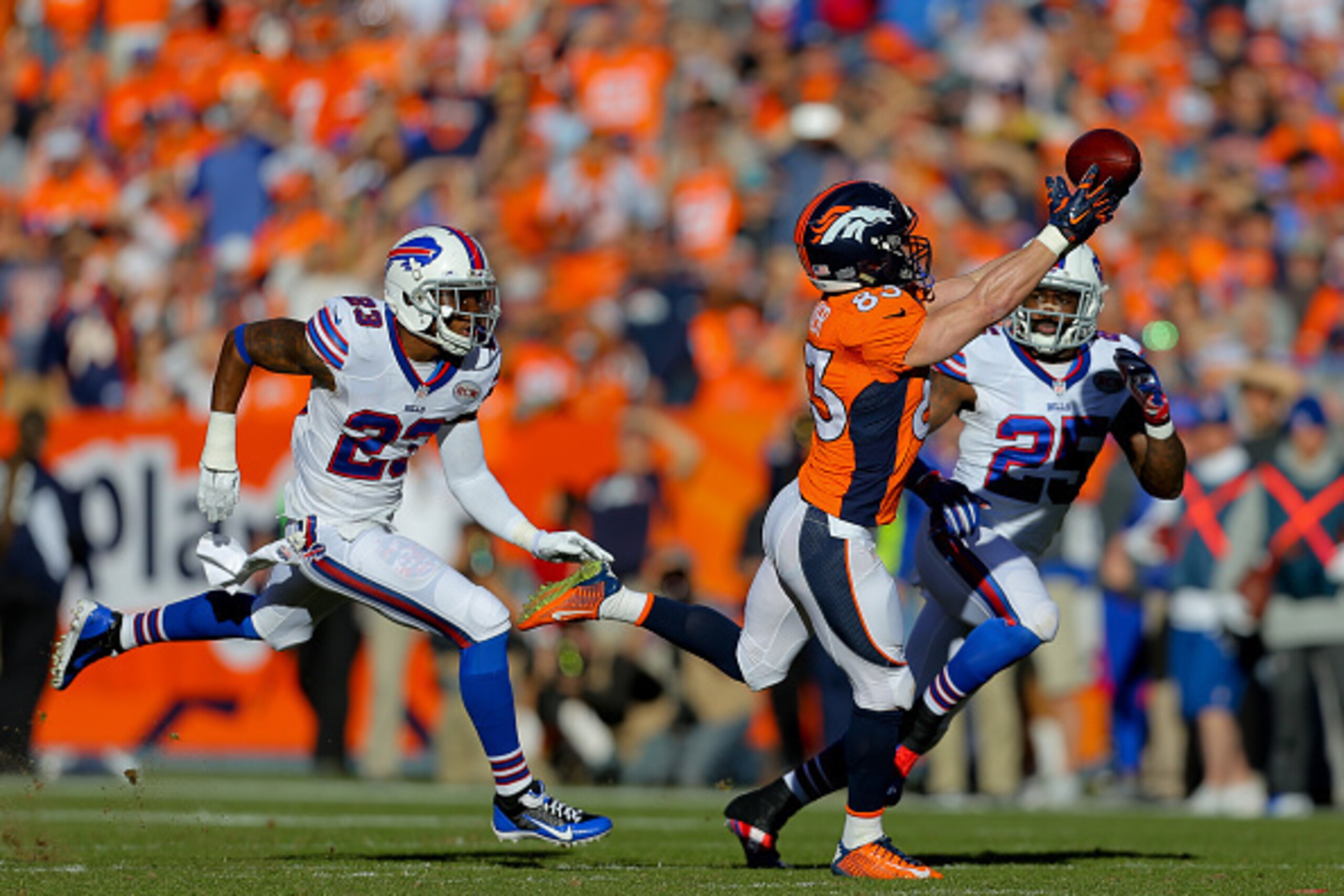 DENVER, CO - DECEMBER 7:  Wide receiver Wes Welker #83 of the Denver Broncos makes a catch for a first down as free safety Aaron Williams #23 of the Buffalo Bills and Da'Norris Searcy #25 defend during the first quarter at Sports Authority Field Field at 