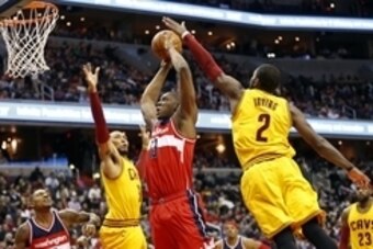 Nov 21, 2014; Washington, DC, USA; Washington Wizards center Kevin Seraphin (13) attempts to dunk the ball as Cleveland Cavaliers guard Kyrie Irving (2) and Cavaliers forward Shawn Marion (31) defend in the second quarter at Verizon Center. The Wizards wo