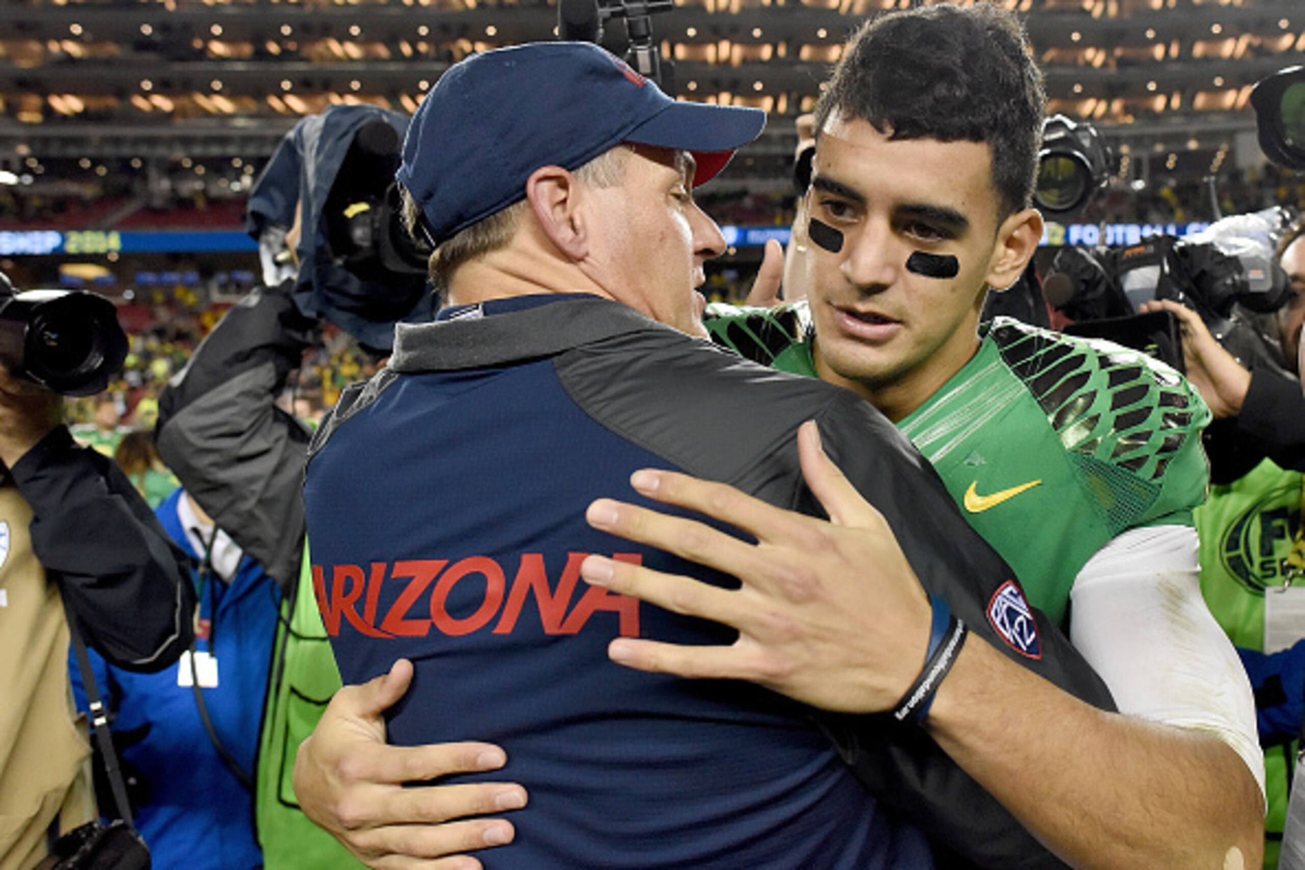 SANTA CLARA, CA - DECEMBER 05:  Head coach Rich Rodriguez of the Arizona Wildcats congratulates Marcus Mariota #8 of the Oregon Ducks after the Ducks defeated the Wildcats in the Pac-12 Championship game 51-13 at Levi's Stadium on December 5, 2014 in Sant
