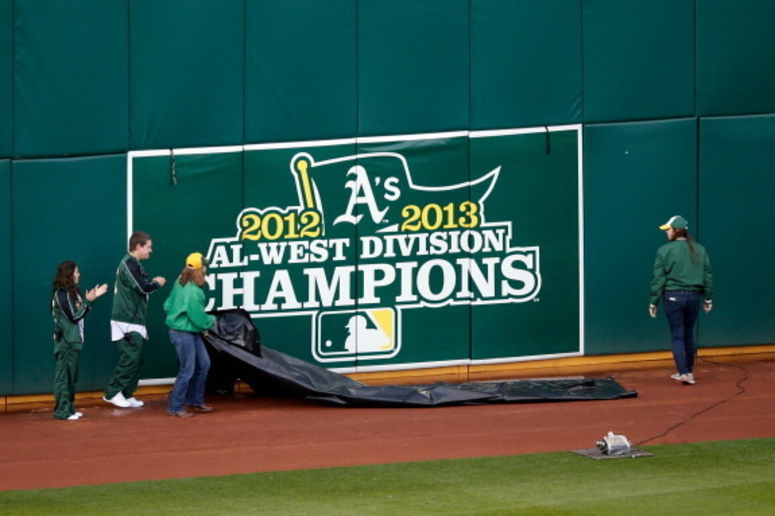 OAKLAND, CA - MARCH 31: A new American League Western Division Champion banner is uncovered on the outfield wall before the Oakland Athletics game against the Cleveland Indians on Opening Day at O.co Coliseum on March 31, 2014 in Oakland, California. (P OAKLAND, CA - MARCH 31: A new American League Western Division Champion banner is uncovered on the outfield wall before the Oakland Athletics game against the Cleveland Indians on Opening Day at O.co Coliseum on March 31, 2014 in Oakland, California. (P